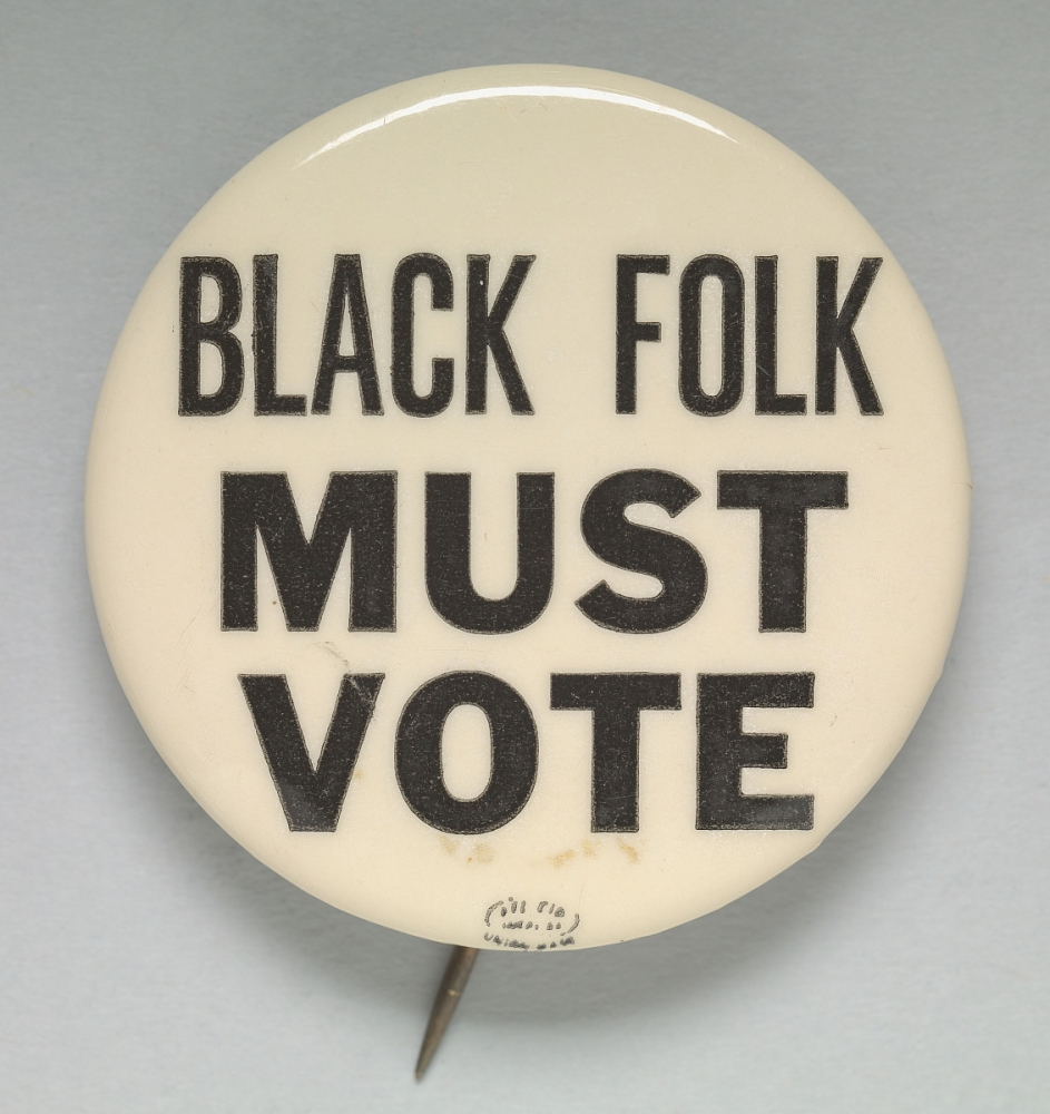 A round pinback button with the text BLACK FOLK MUST VOTE in bold black letters on a white background.