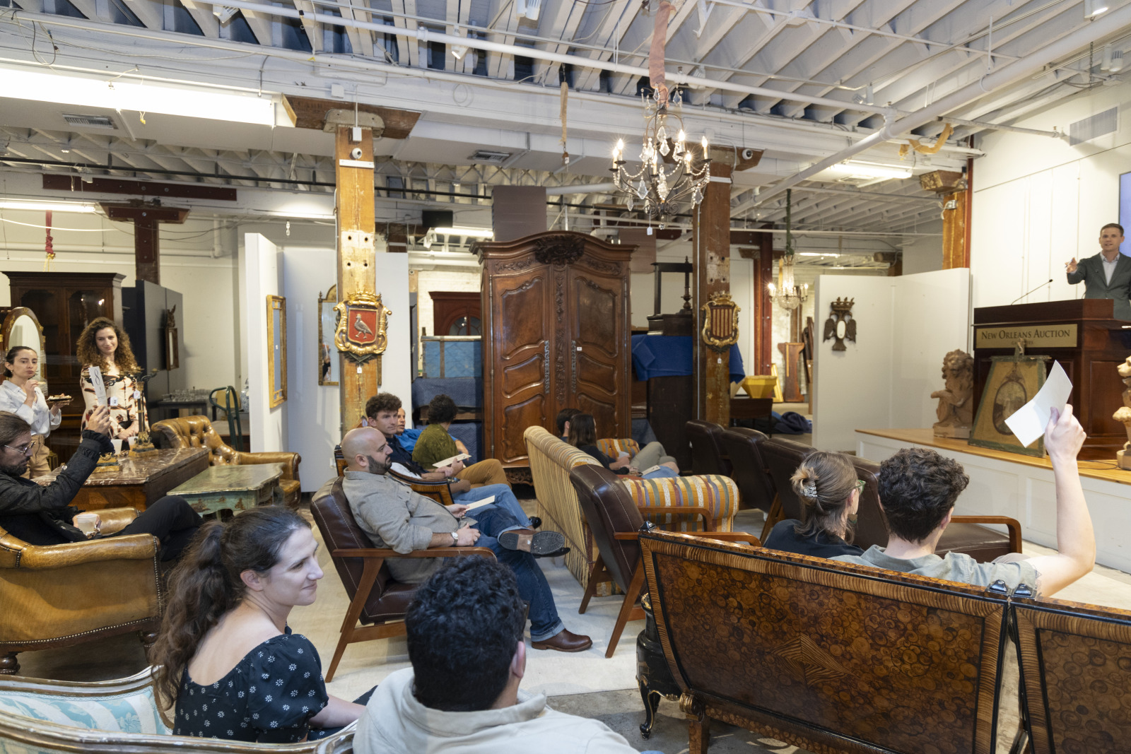 A photo of an auction house, featuring several young people participating in an auction.