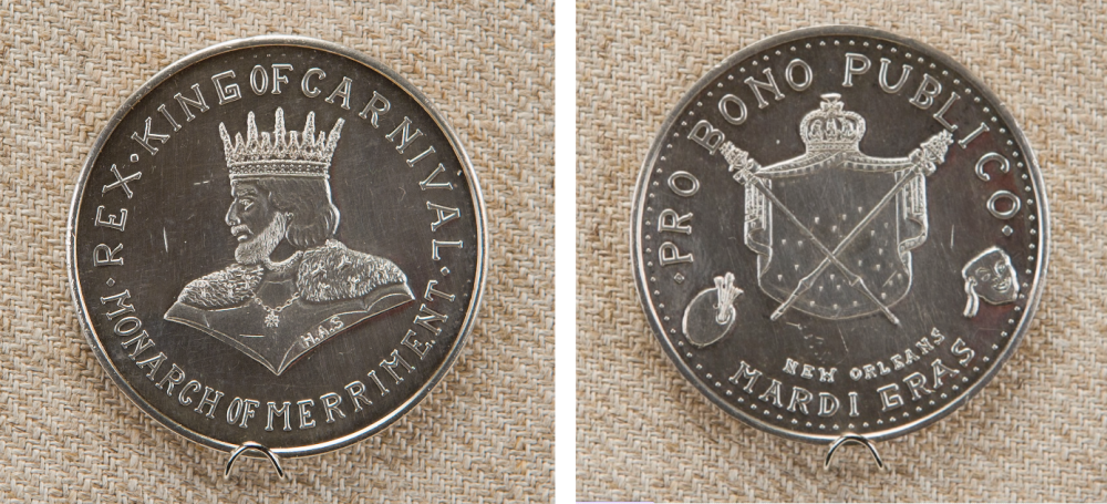 The image shows both sides of a silver New Orleans Mardi Gras coin. One side features the Rex King of Carnival with a crowned figure; the other side shows the Pro Bono Publico crest, crossed scepters, and a bag, with text referring to Mardi Gras.