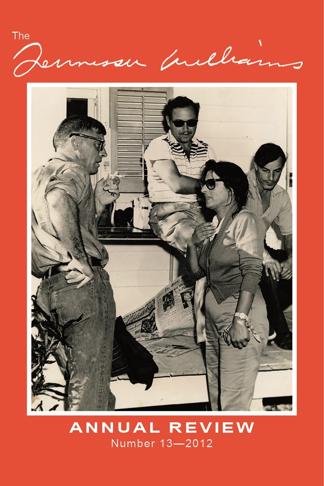 Four people are gathered on a porch, engaged in conversation. Two men are sitting, one is standing with arms crossed, and one woman is standing, smiling. The image is on the cover of a magazine titled The Tennessee Williams Annual Review 2012.