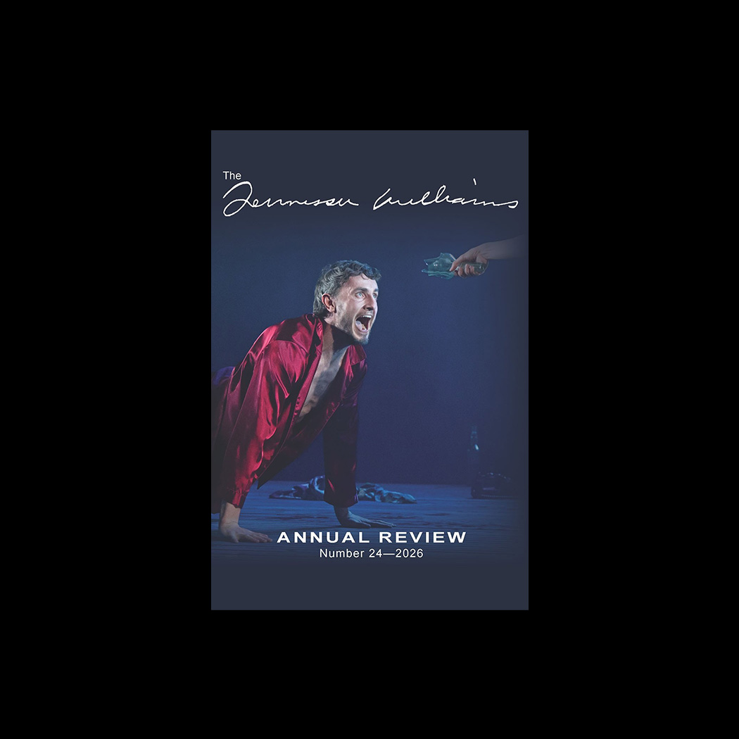 Journal cover with photograph of scene from a stage performance: on the left side, a young man wearing red pajamas crouches on stage and yells angrily at an unseen person whose hand extends toward him from the right side of the image, holding the neck of a broken glass bottle.