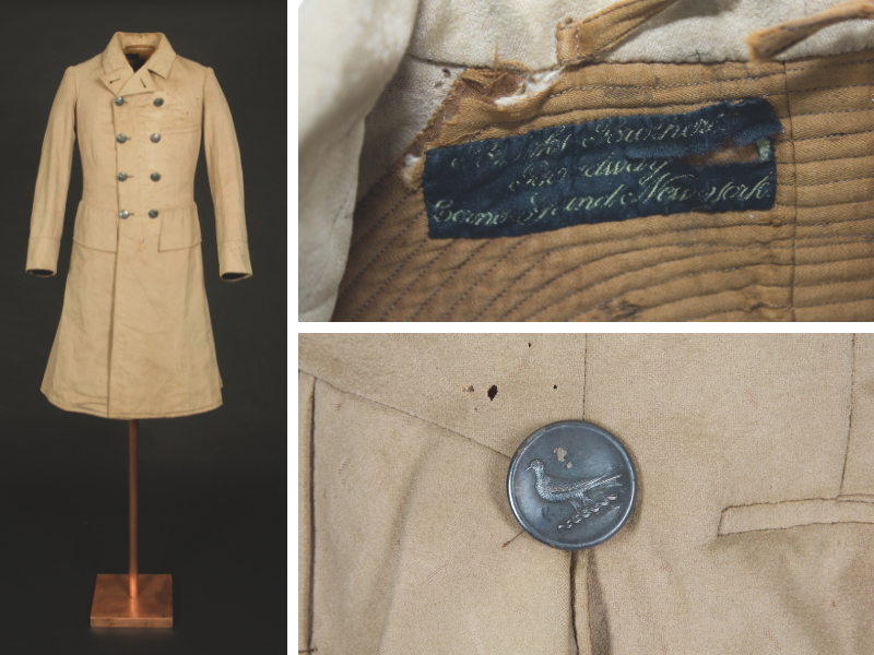 A vintage beige coat on a stand with a double-breasted design and metal buttons featuring a bird motif. Close-up images show a worn label inside and a detailed view of one button.