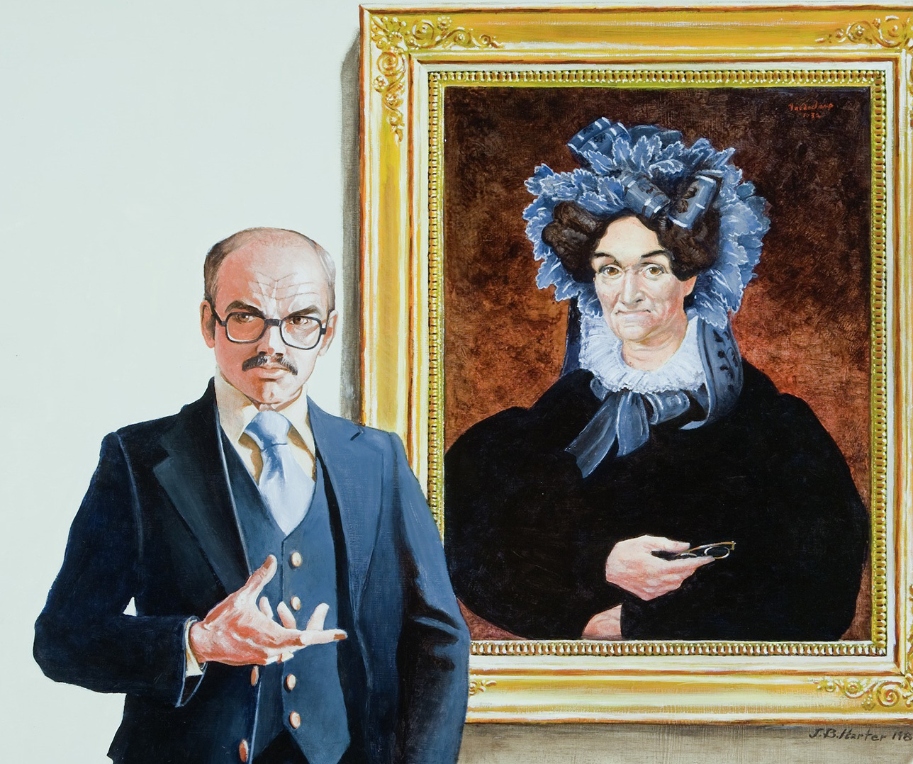 A man in a suit and glasses poses with a hand gesture in front of a framed portrait of a woman in historical attire, wearing a blue bonnet and holding an object. Both appear poised and formal.