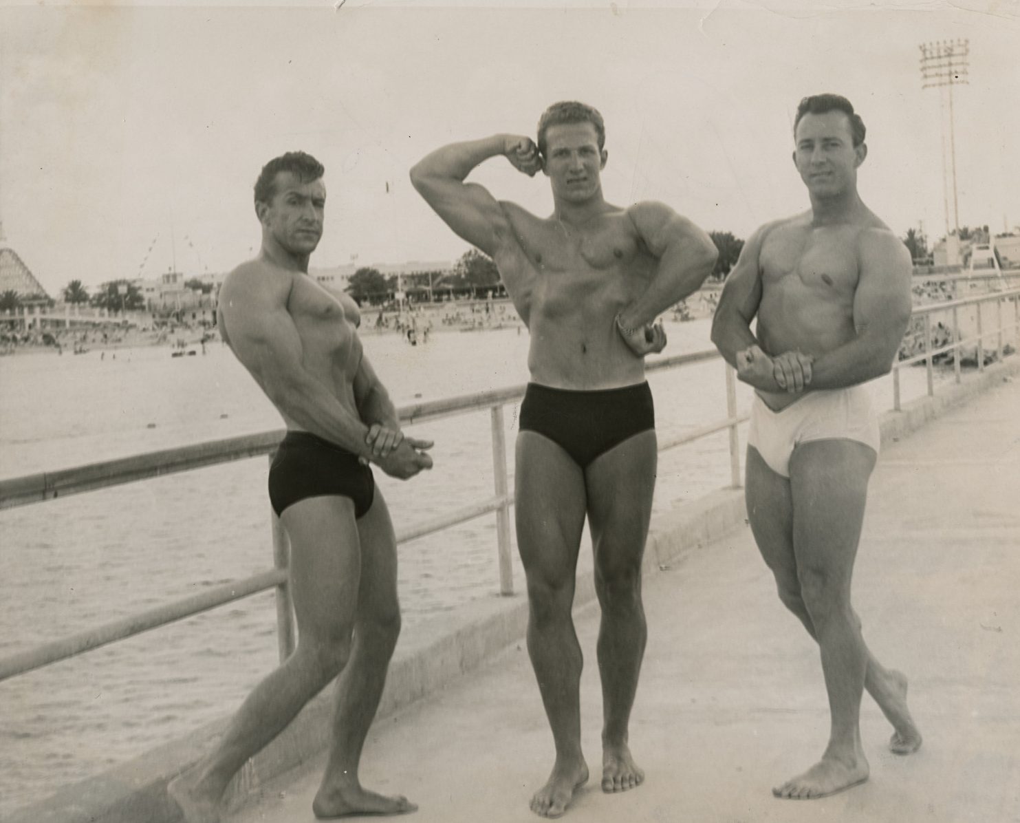 Three athletic men pose for Pontchartrain Beach amusement park’s Mr. New Orleans competition, between 1955 and 1965.