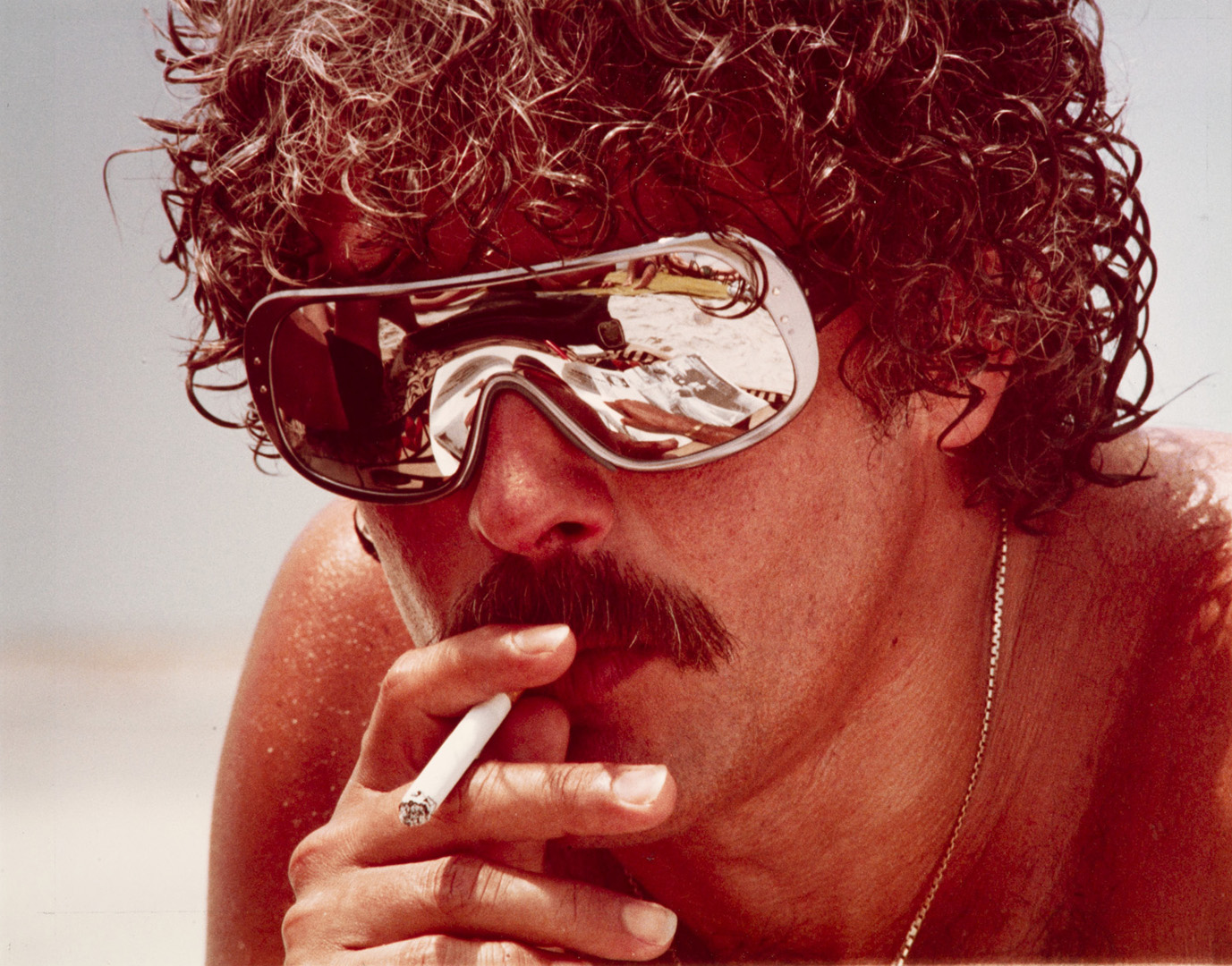 George Febres wearing reflective sunglasses and smoking a cigarette