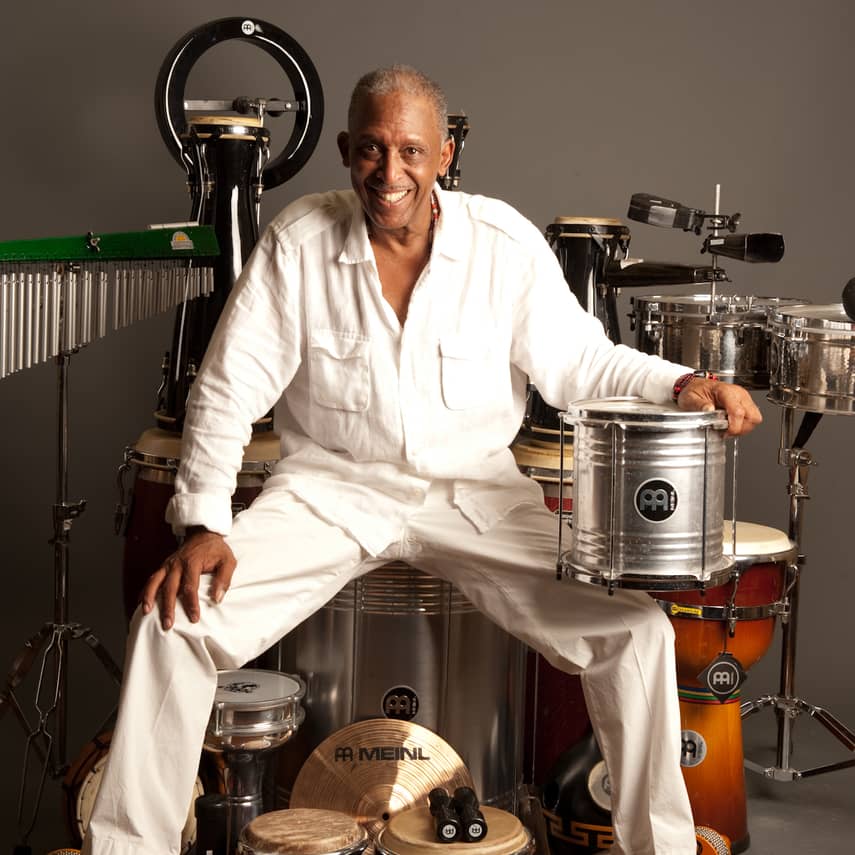 Photo of Bill Summers surrounded by percussion instruments.