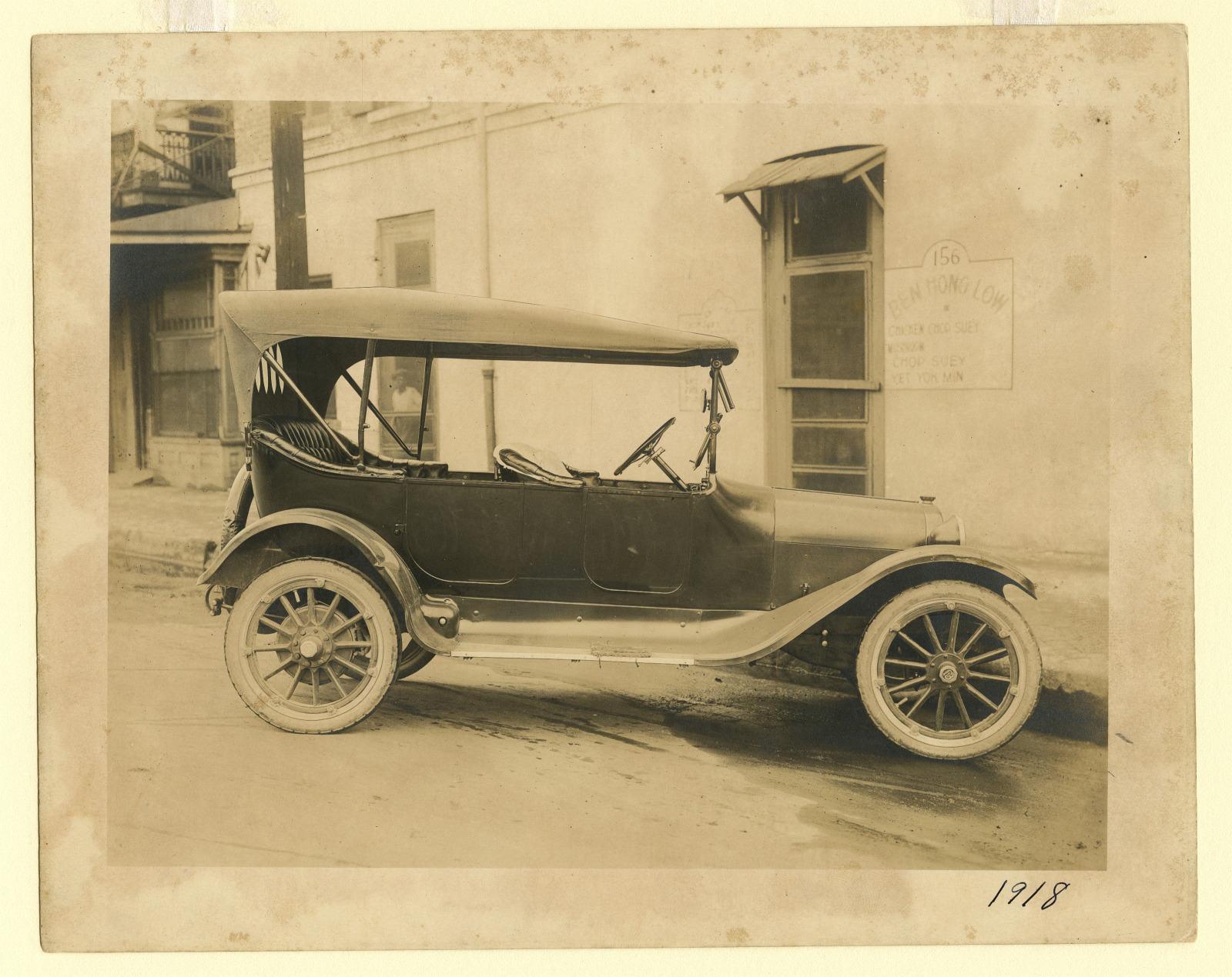 Automobile parked at Ben Hong Low restaurant, 156 Basin Street in 1918.