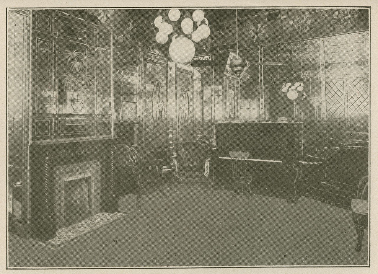 A vintage black and white photo of an elegant room with a fireplace, armchairs, a piano, and ornate mirrors on the walls. The ceiling features round light fixtures, creating a luxurious and classic atmosphere.