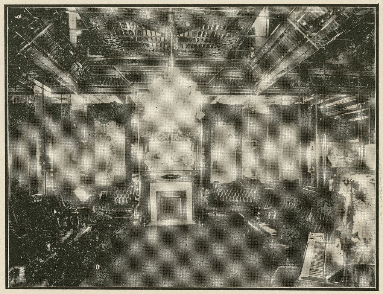 Sepia-toned vintage photo of an ornate, opulent room with a chandelier, ornate fireplace, and velvet furniture. Decorative wall panels and intricate ceiling designs are visible, evoking an early 20th-century luxurious interior.