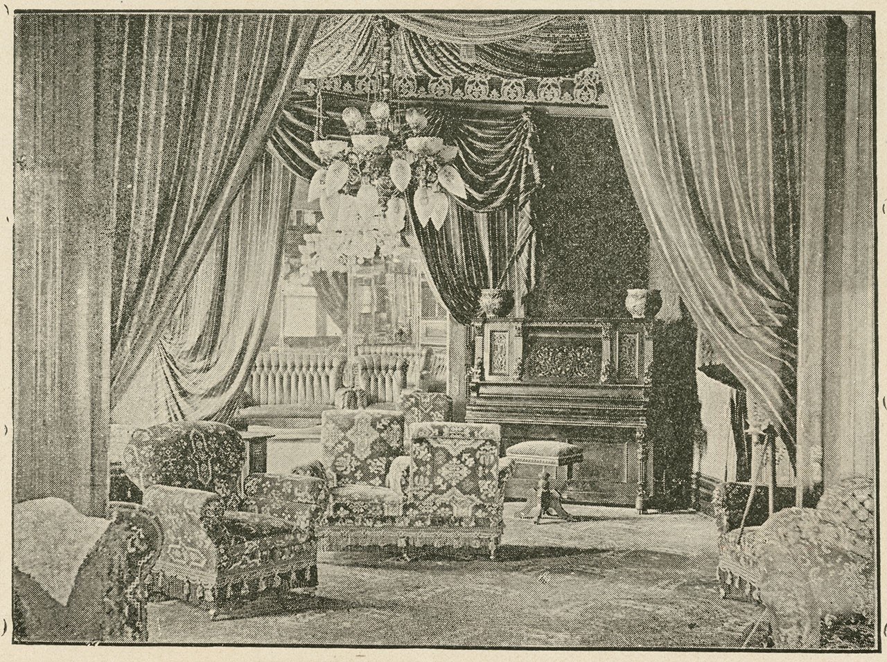 A vintage photograph of an ornate living room with patterned armchairs, an elaborate chandelier, heavy drapes, and a large wooden cabinet in the background. The room has a classical and luxurious style.