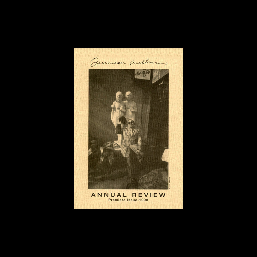 Sepia-toned cover of Annual Review Premier Issue: 1998 featuring a person in a suit and top hat, holding a cane, with two masked figures in the background. Handwritten text appears at the top.