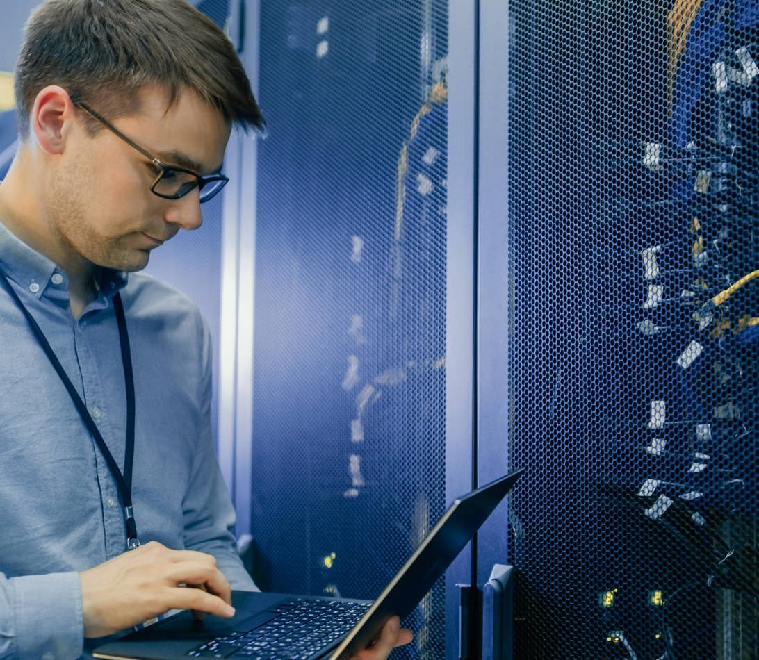 Technician checking laptop network server rack