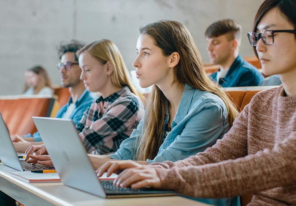 University students with laptops during a class