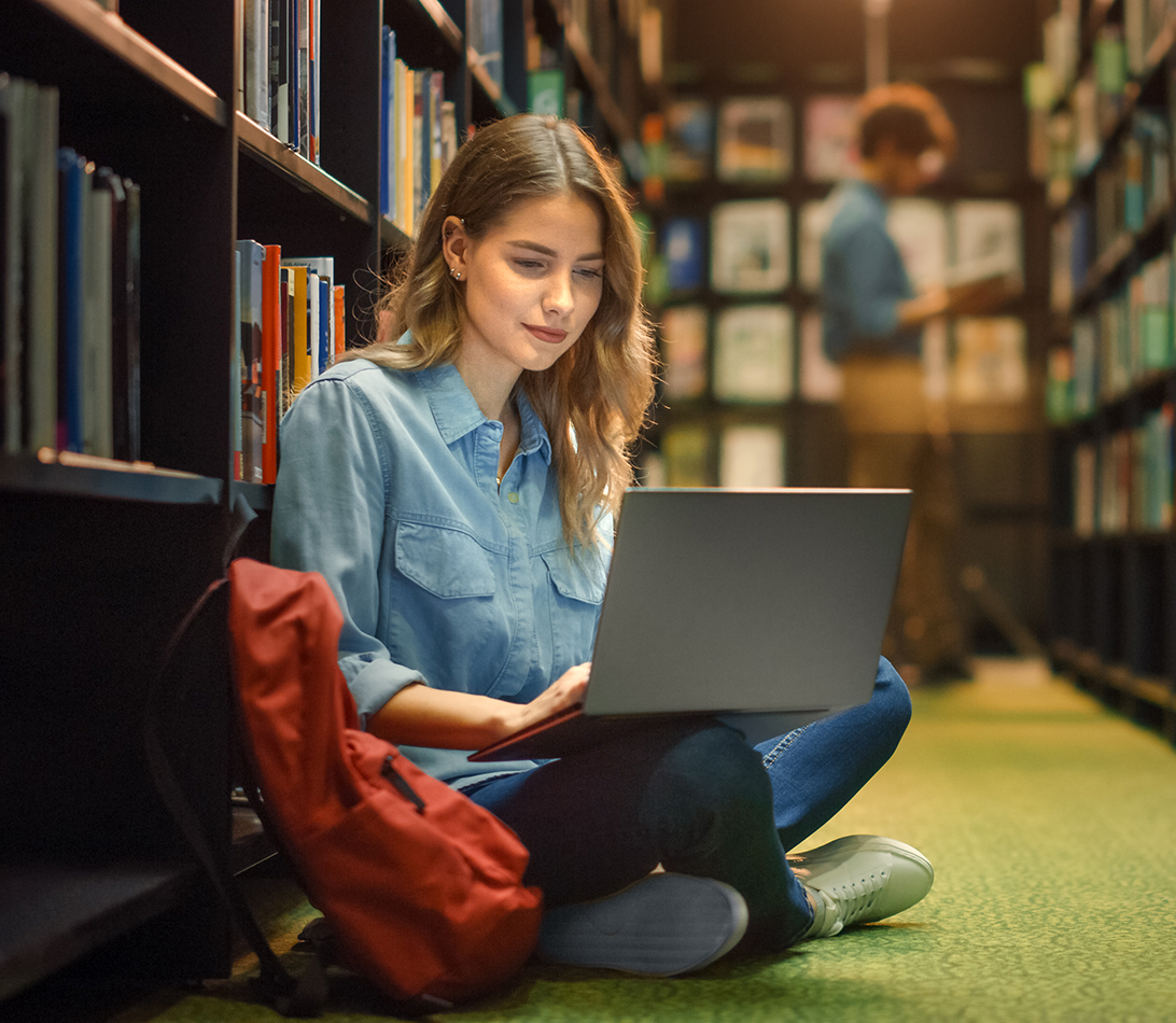 Woman working on a laptop in a library galleries libraries and museums GLAMs
