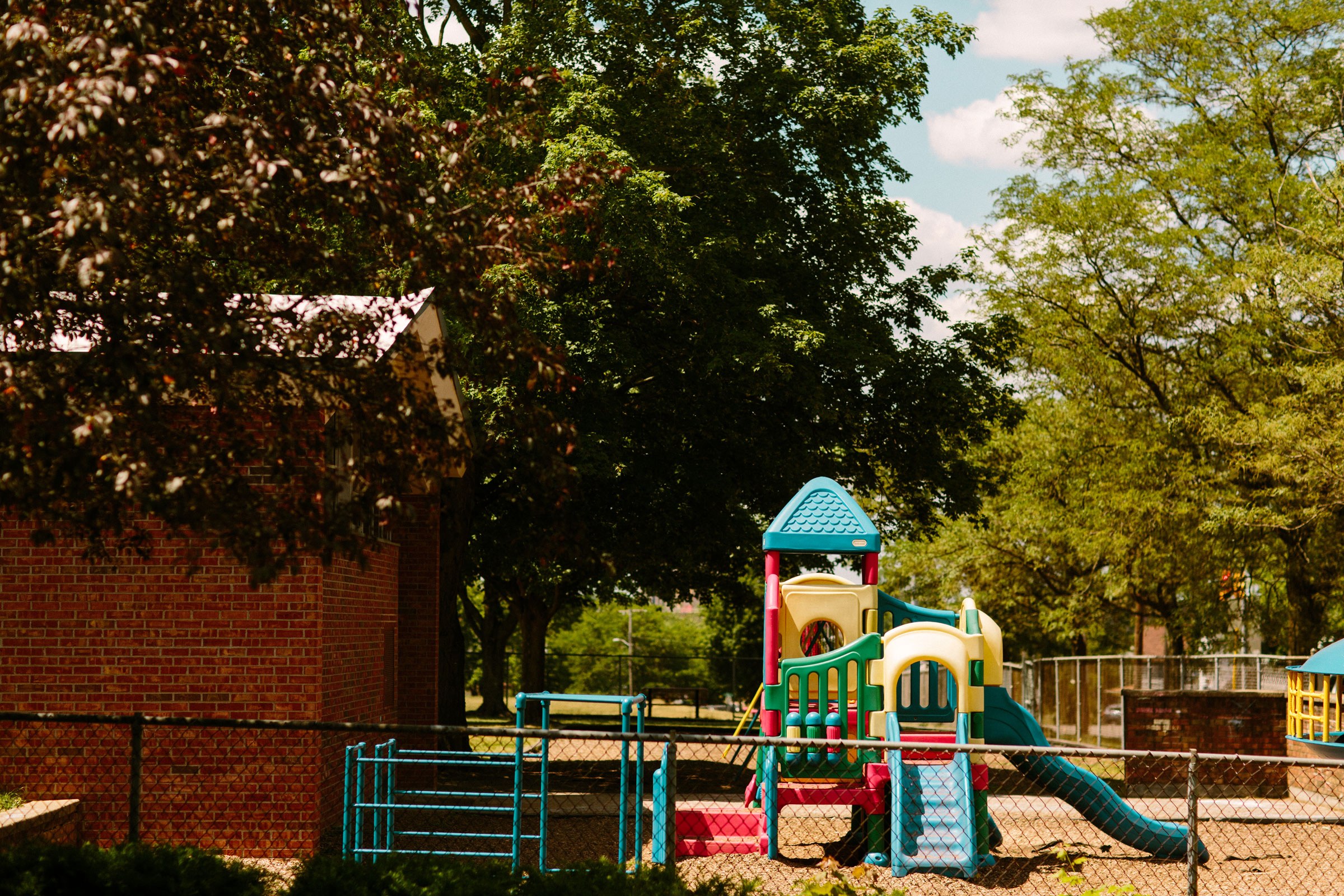 The playground of Post-Franklin sits outside the building under trees