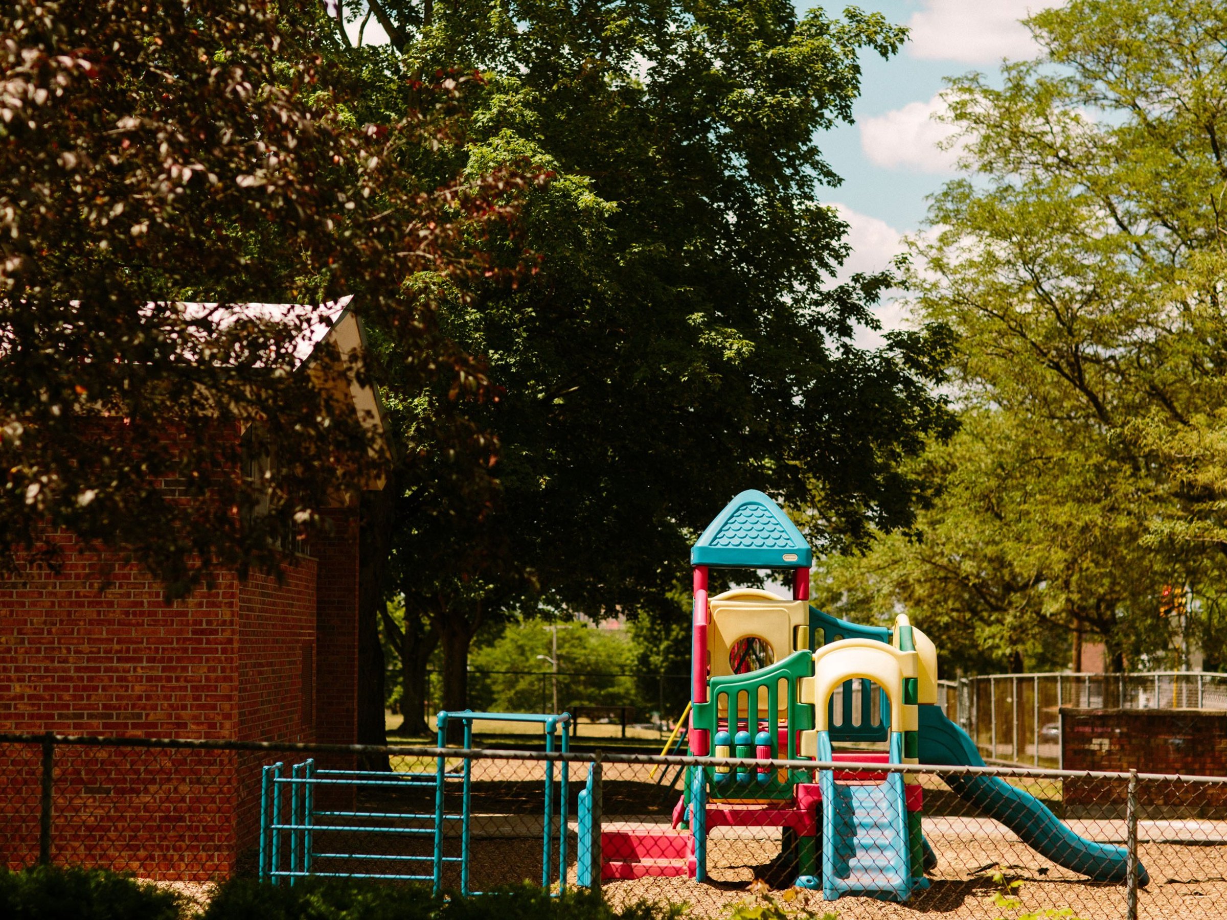 The playground of Post-Franklin sits outside the building under trees