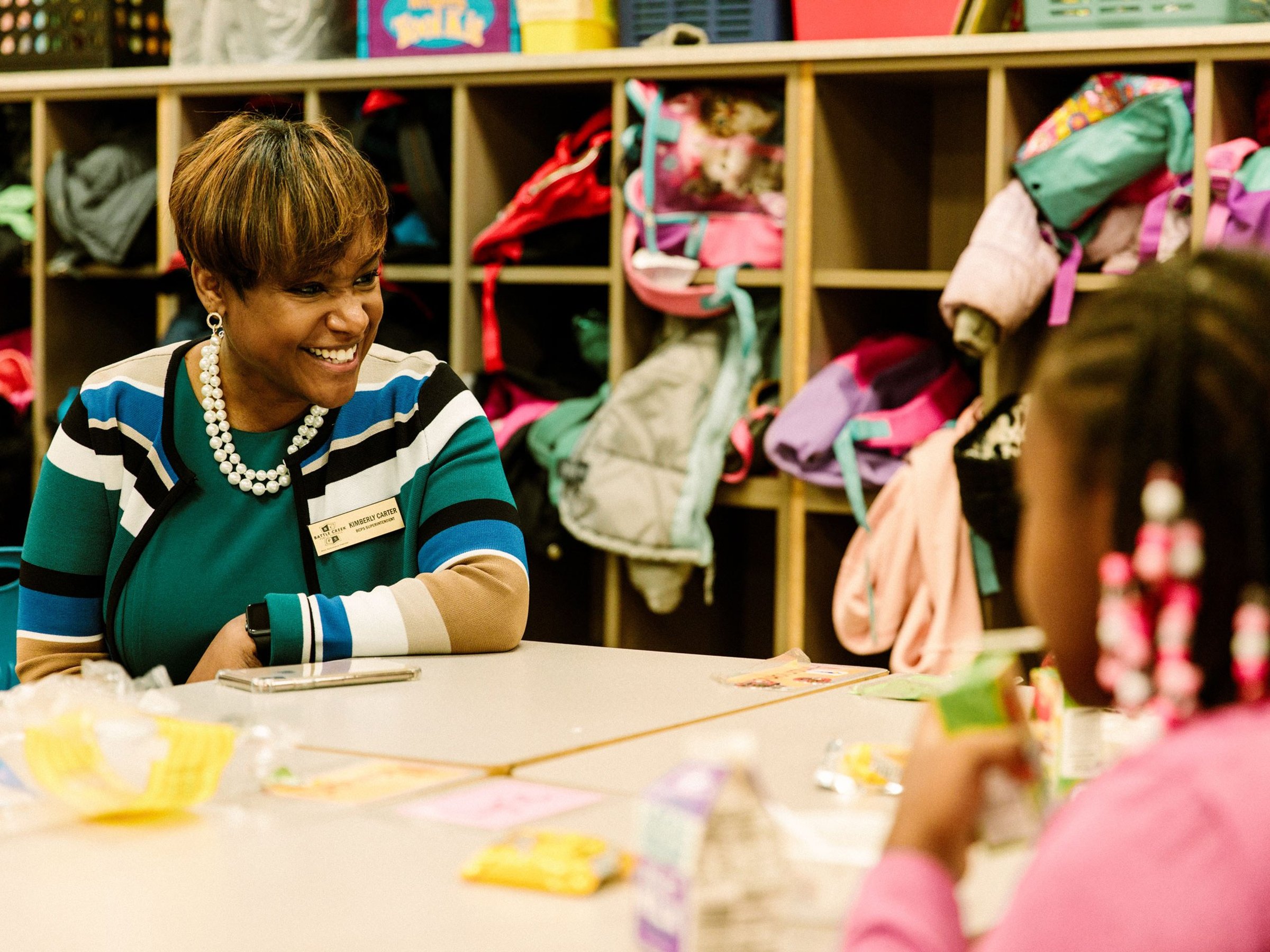 Superintendent Kim Carter sits at a table with students in a classroom