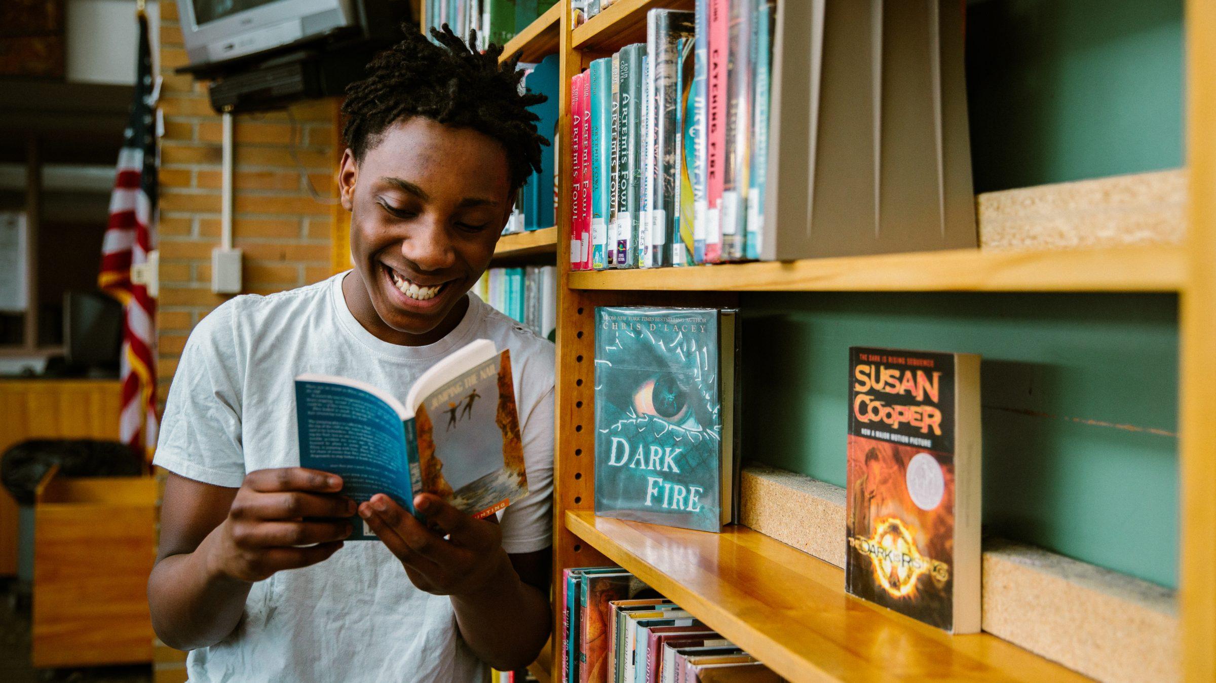 Boy reading book in library