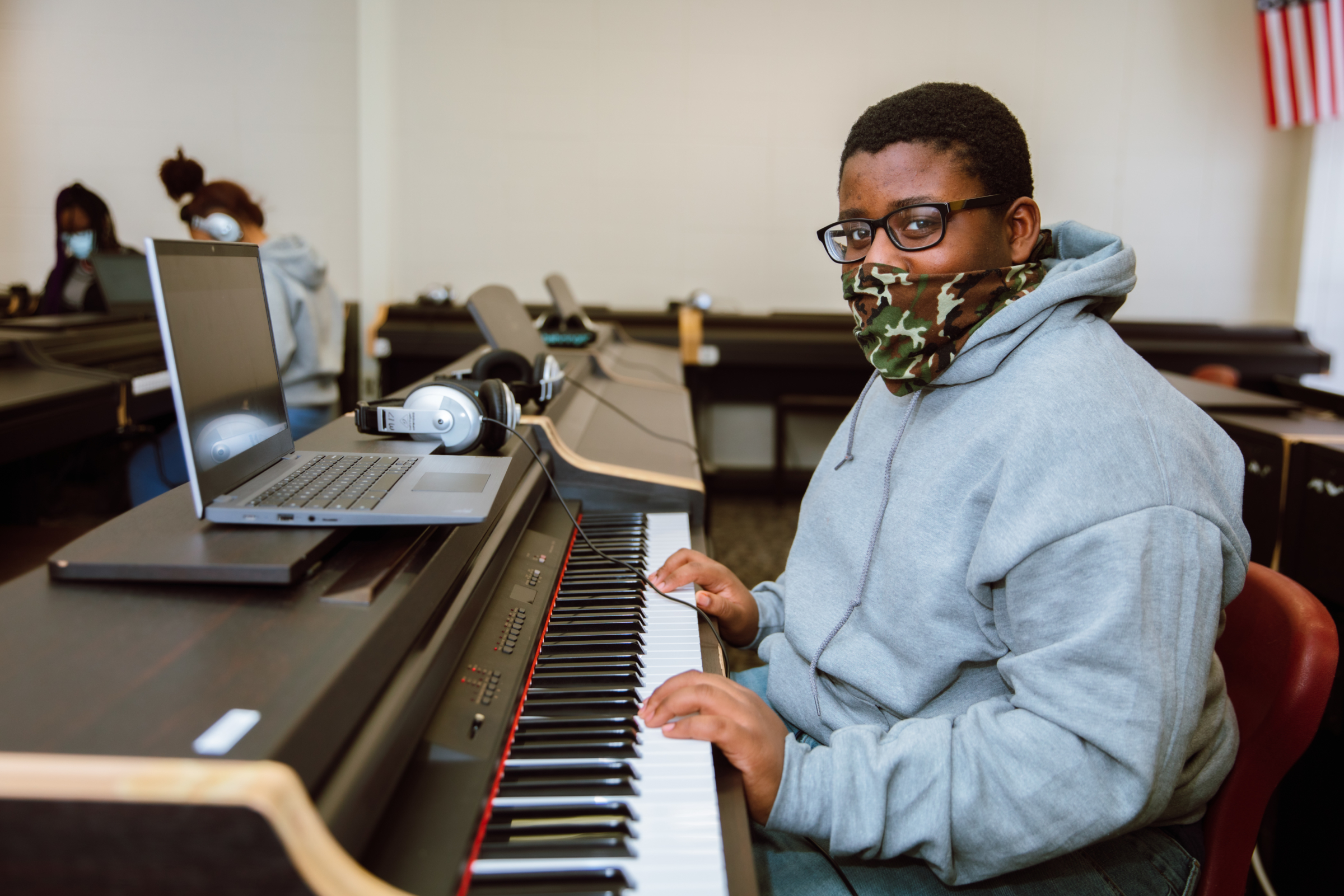 student in mask at keyboard