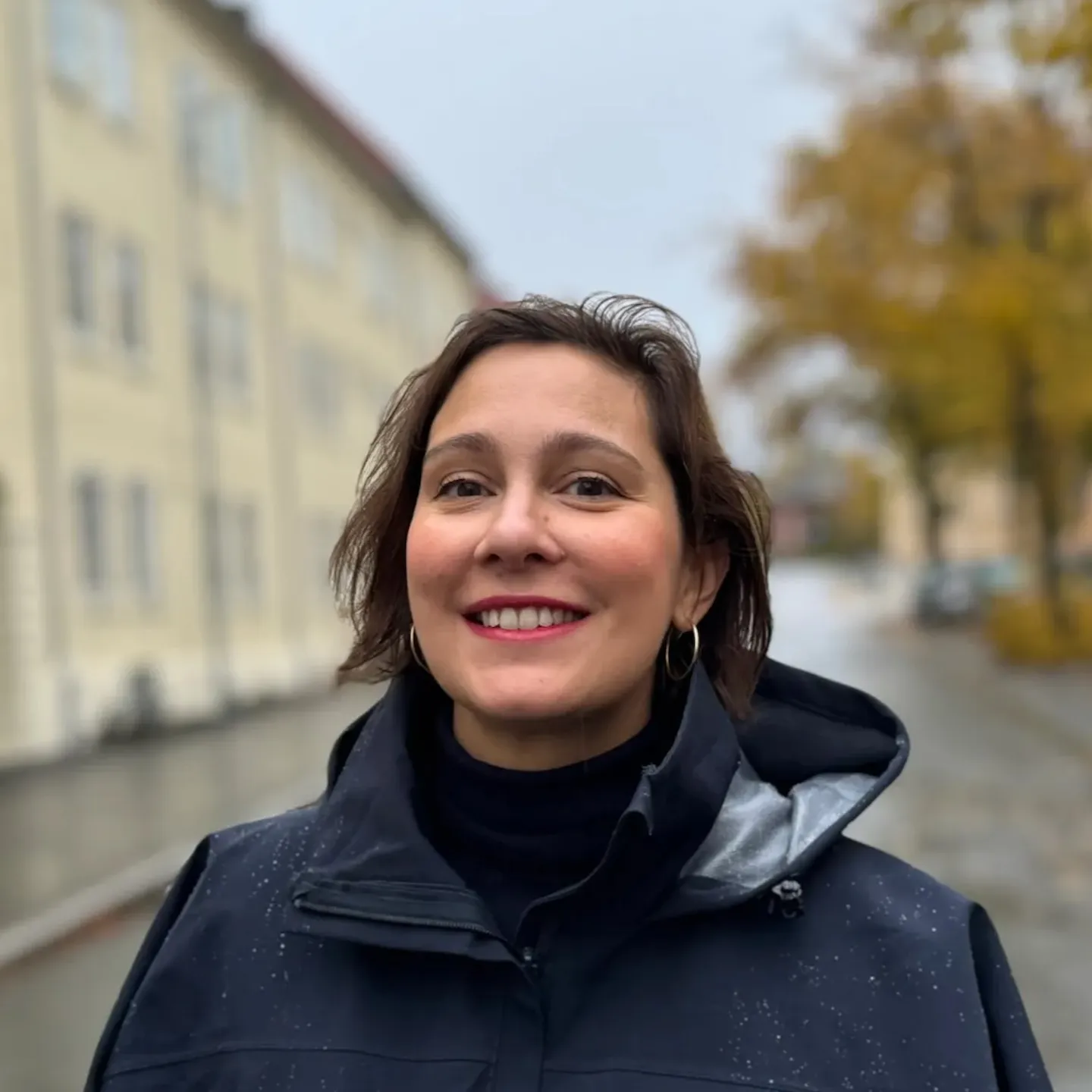 Foto av Nadja Sahbegovic som smiler mot kamera med kort, mørkt hår.