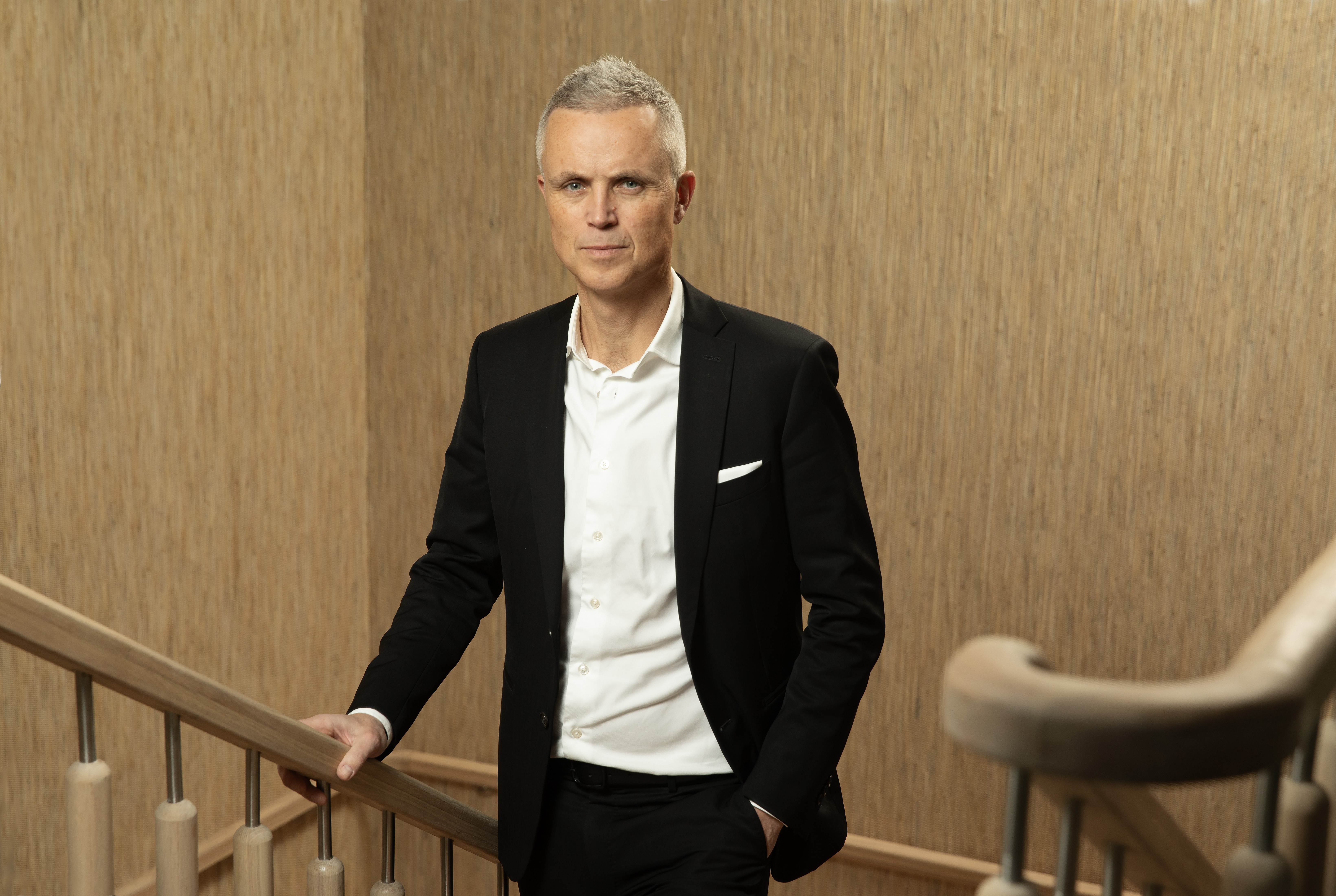Portrett av Tor Inge Hjemdal i trapp med sort blazer.