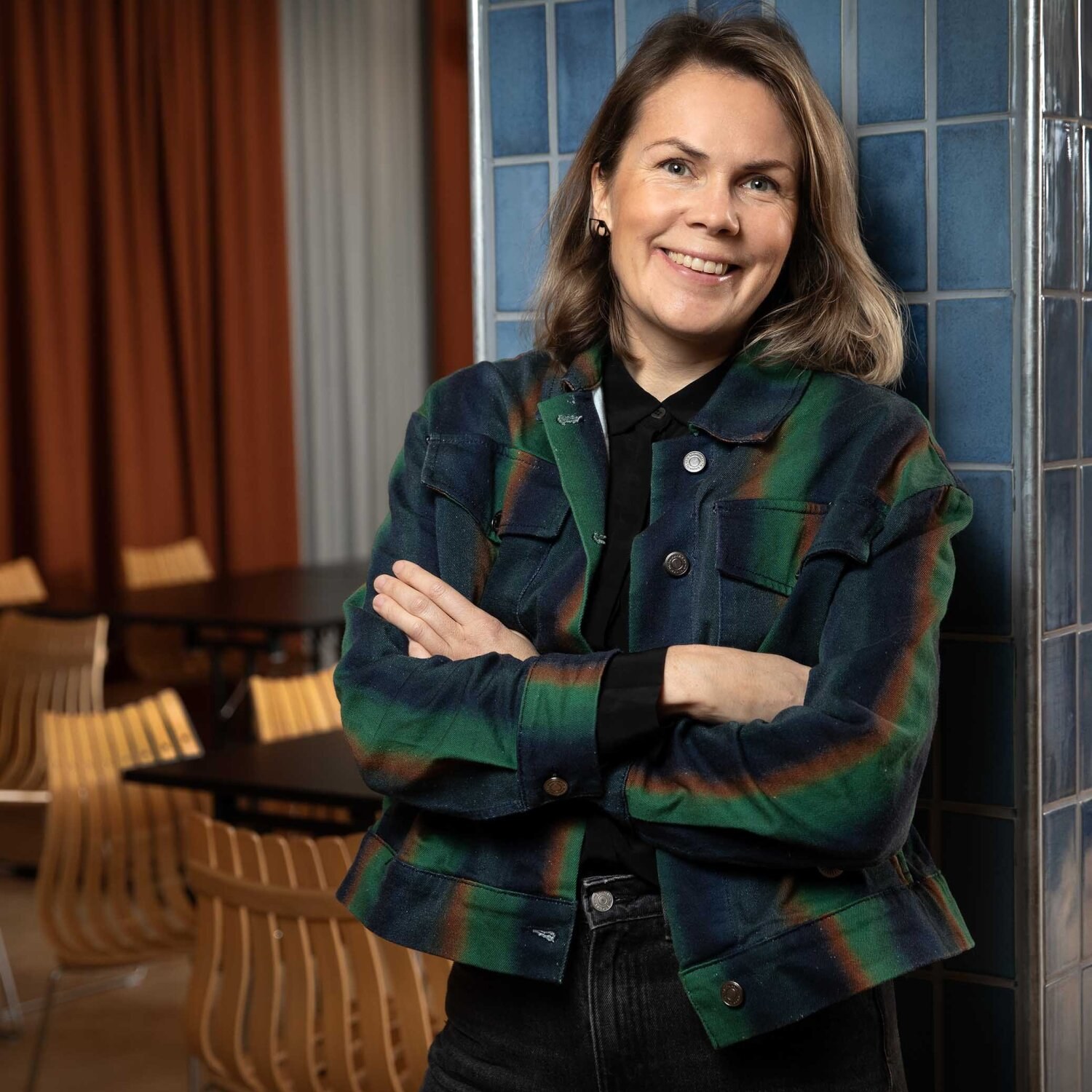 Foto av Malin som smiler mot kamera i en grønnrutete jakke.