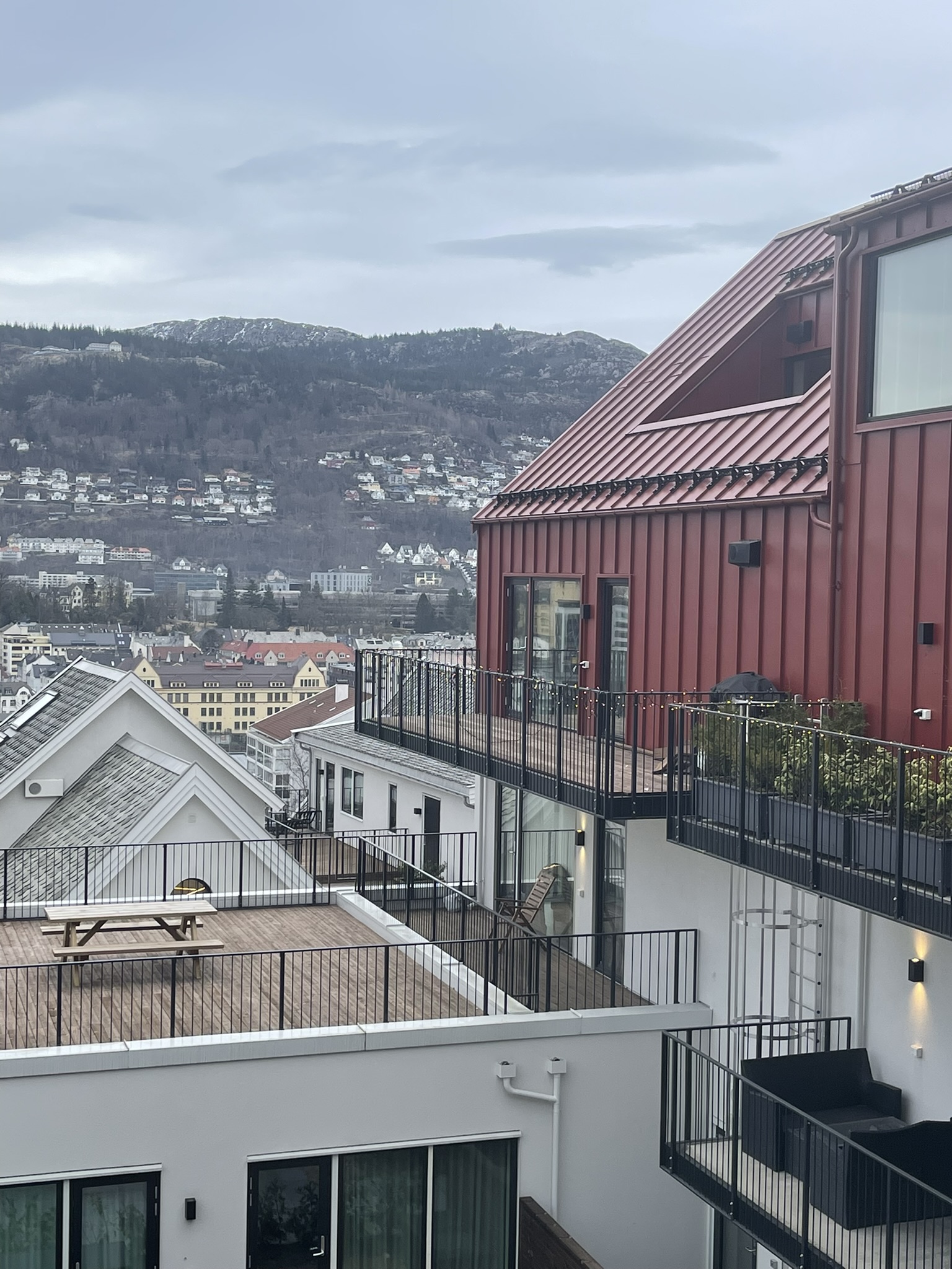 Foto av utsikt over bygninger og en ås i det fjerne.