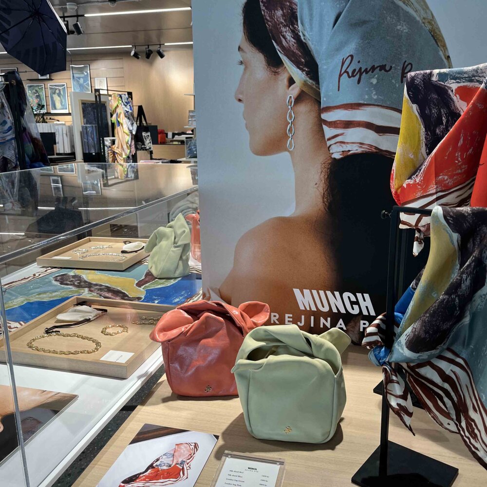 Foto av en samling med vesker, smykker, kjeder og bilder på veggene i et butikklokale.