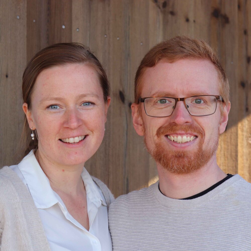 Foto av Julie og Halvor i lyse klær som smiler mot kamera.