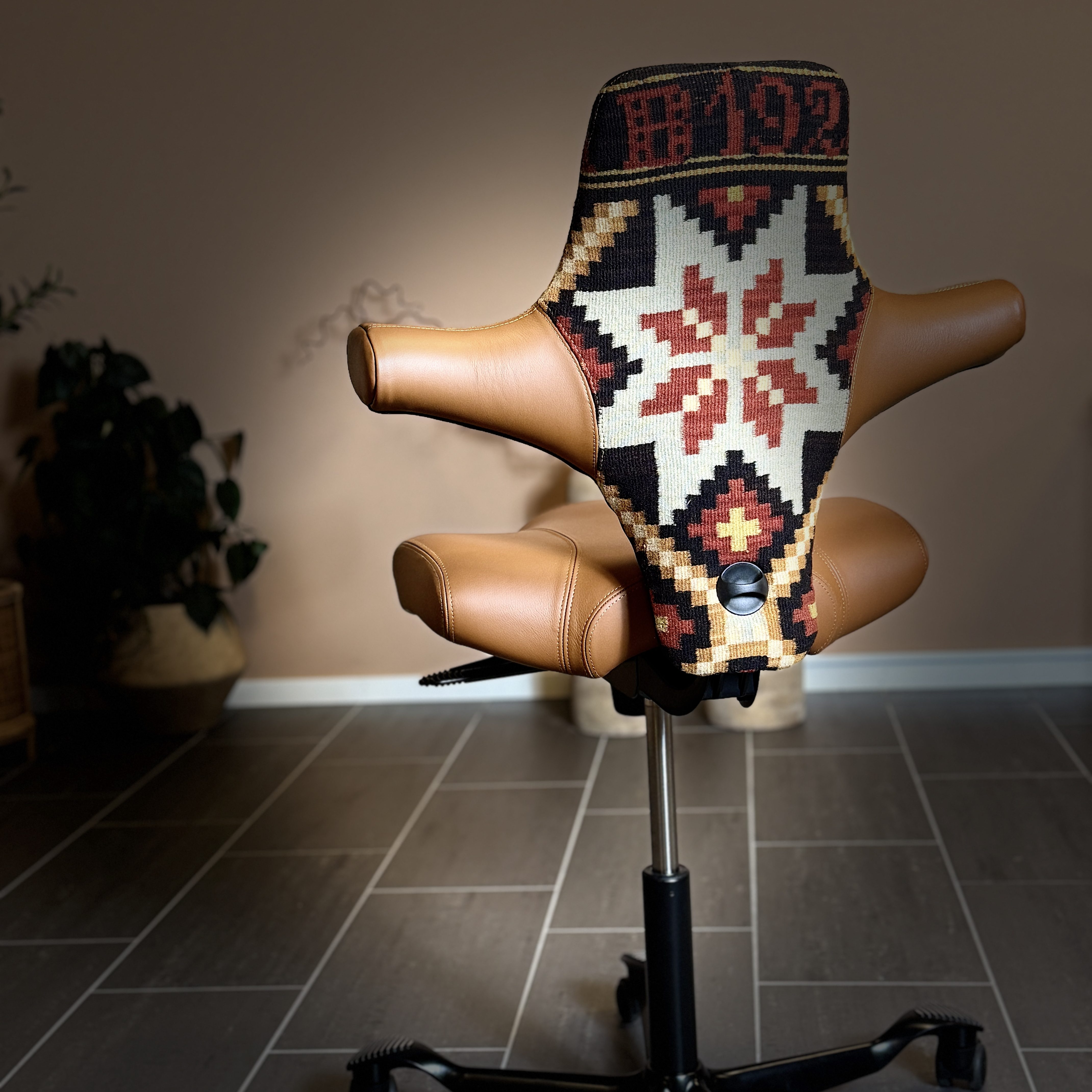 En kontorstol der ryggen er trukket med et stoff vevd i tradisjonelle norske mønstre.