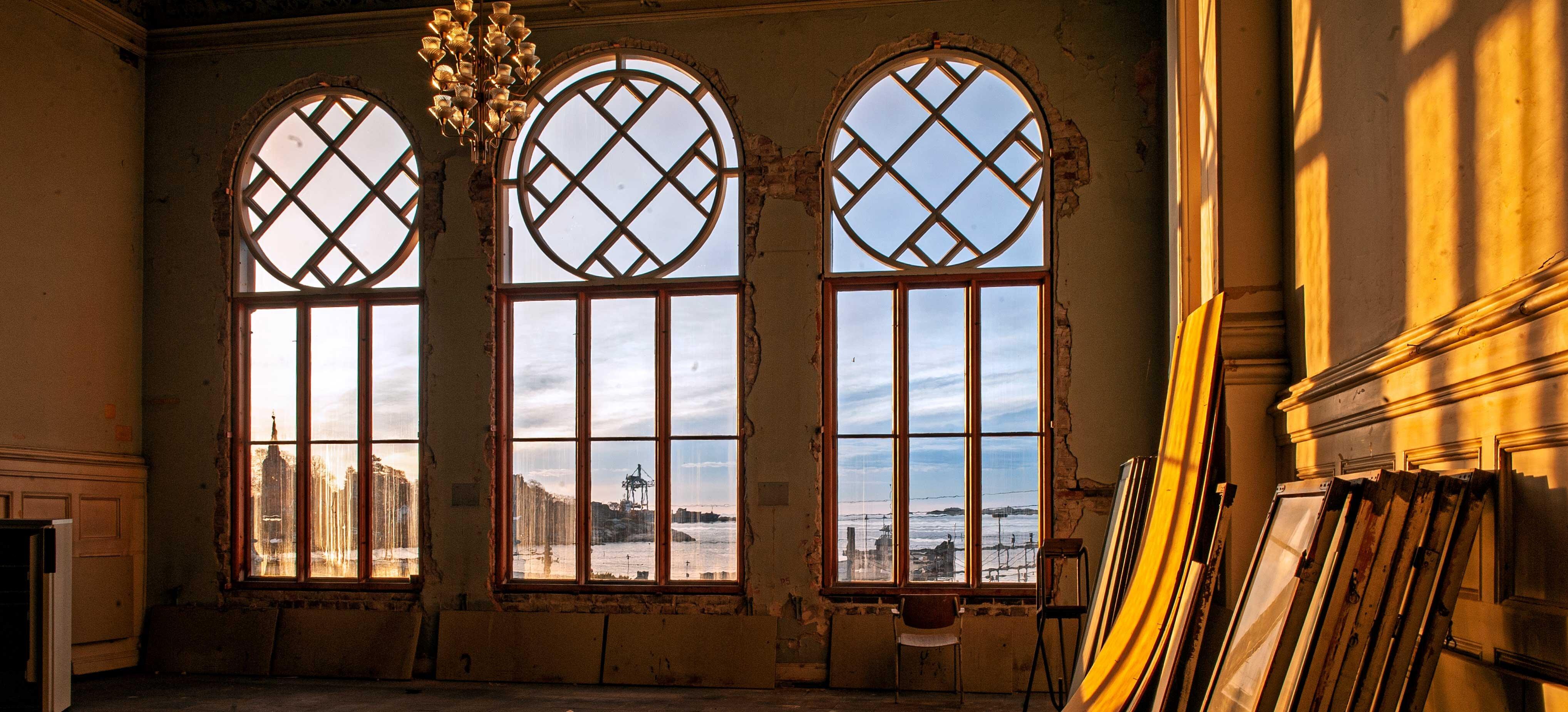 Fra innsiden av bygget ser vi ut tre unikt utformede buede vinduer.