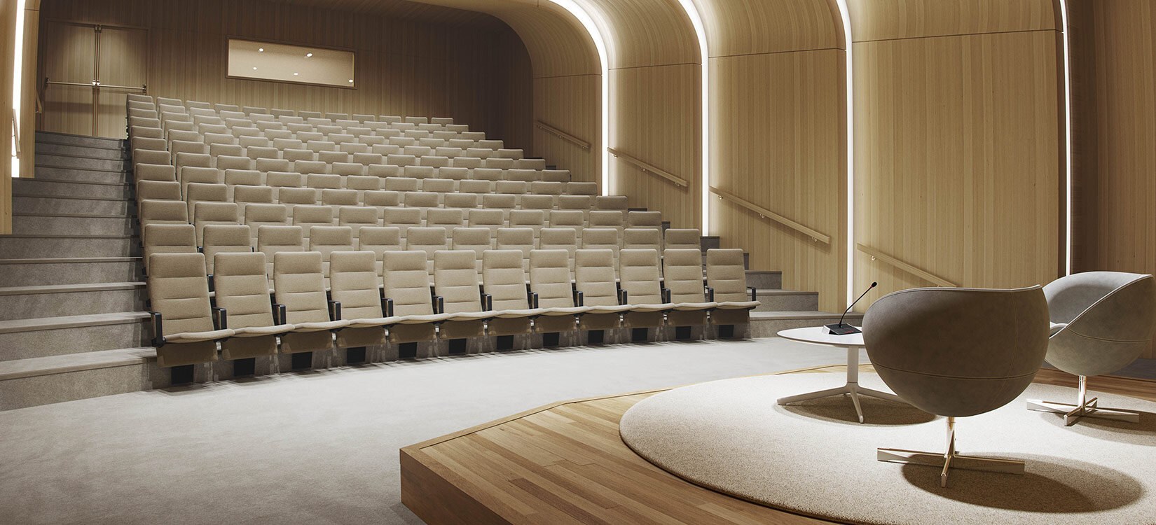 En moderne auditoriumssal med lys beige innredning. Salen er sett fra froskeperspektiv.