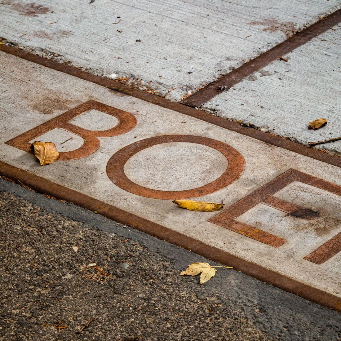 Nærbilde av bokstaver i bakken: BOE...