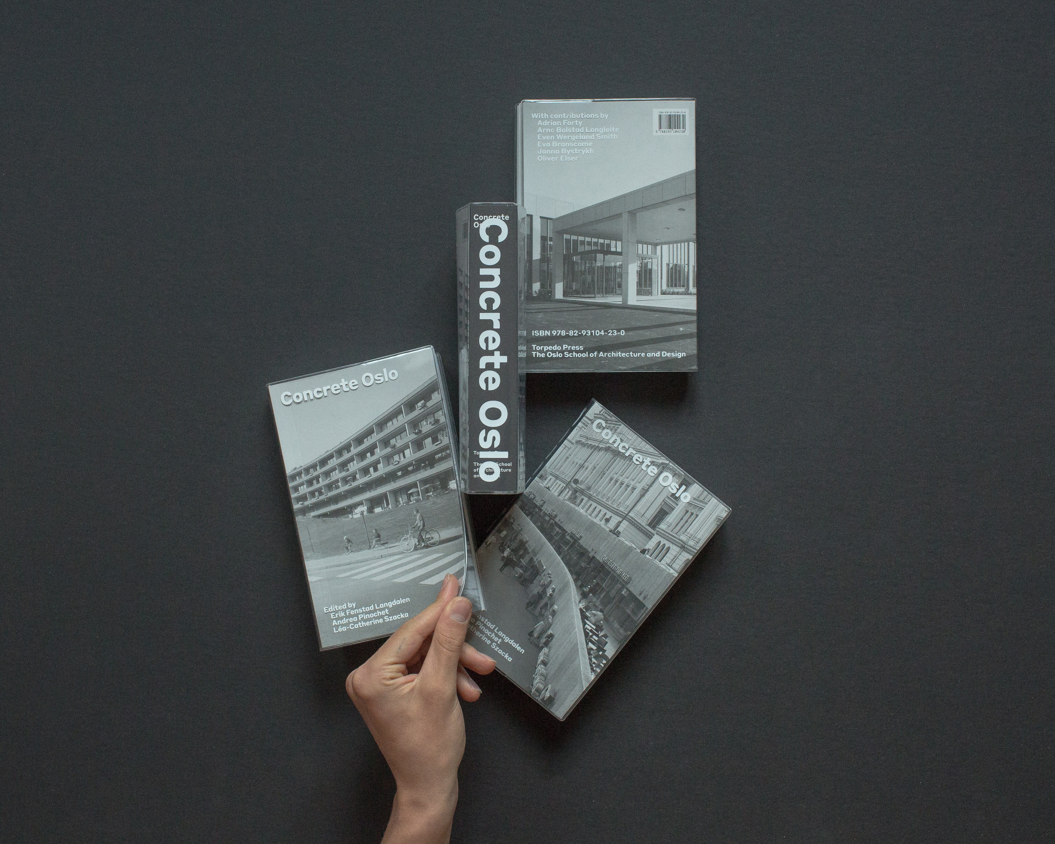 Kopier av en Concrete Oslo: en meg bokryggen opp – to ulike varianter av forsiden og en med baksiden opp.