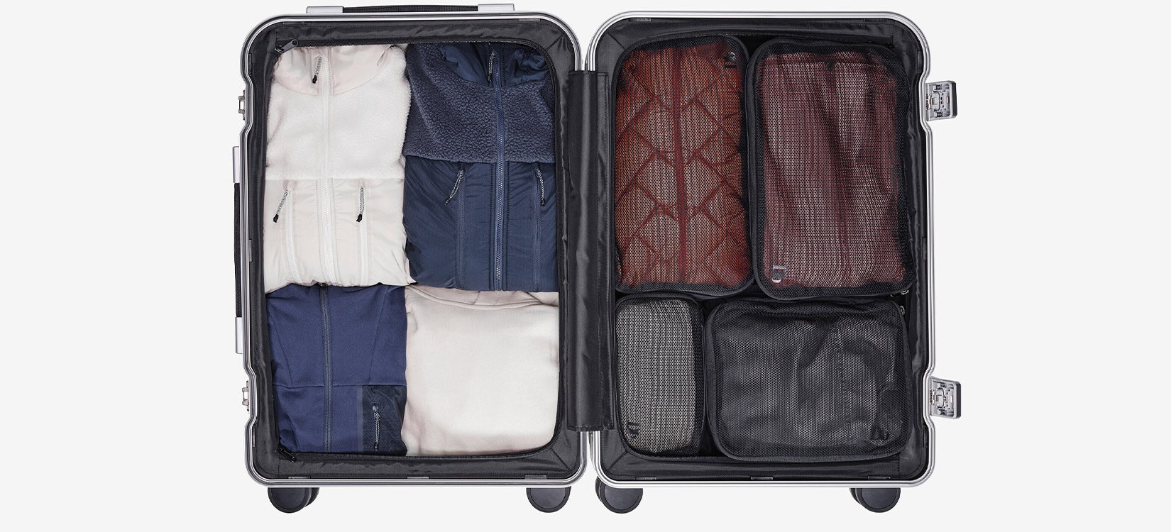 Produktfoto av innsiden av en åpen koffert med klær som er ryddig organisert.