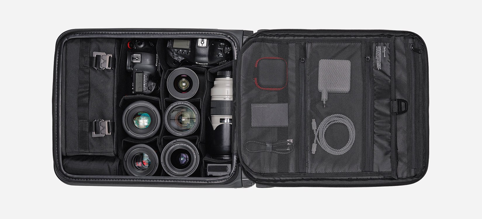Produktfoto av innsiden av en åpen koffert med fotoutstyr som er ryddig organisert.