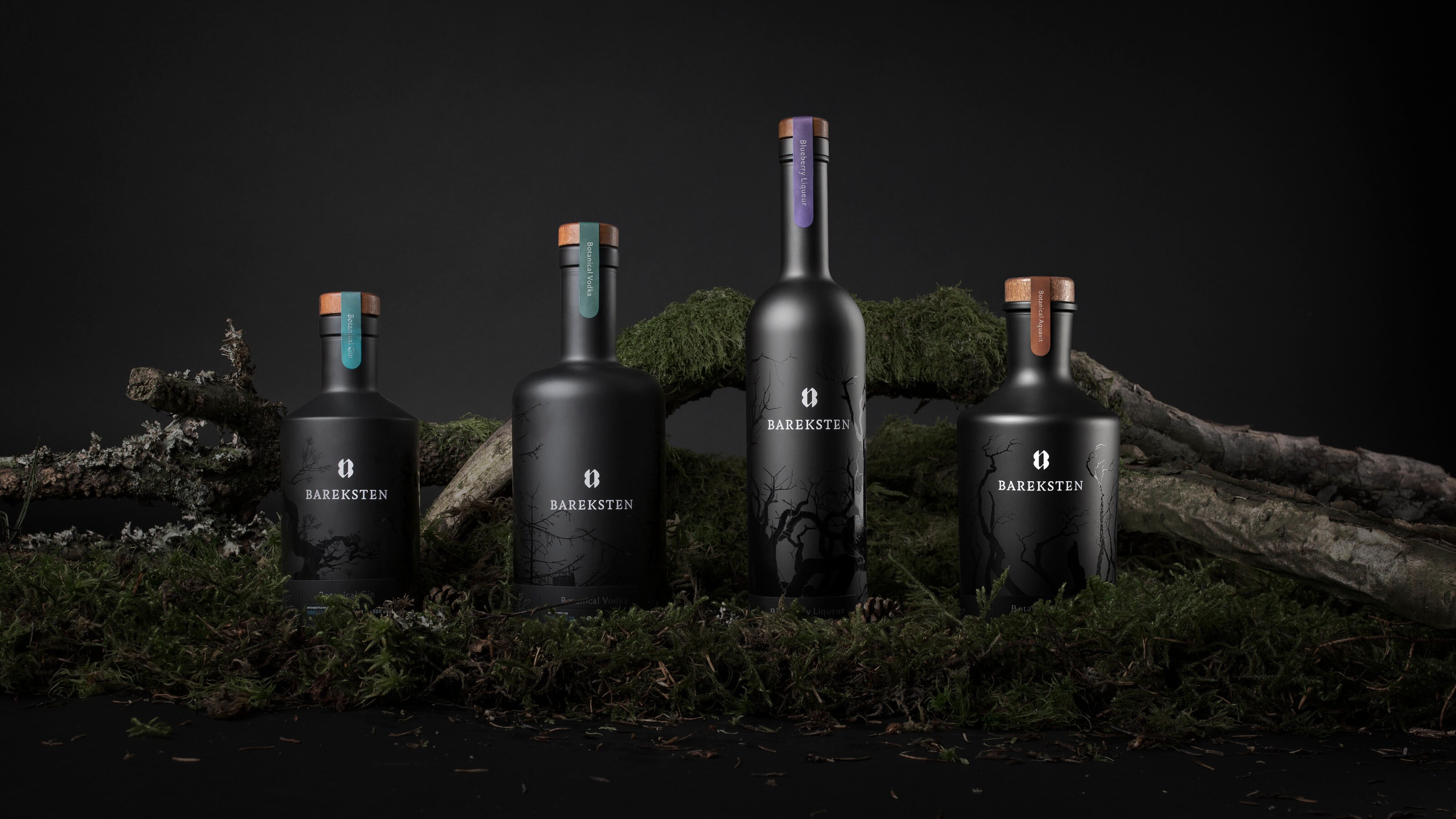 Foto av fire mørke flasker i stilrent design.