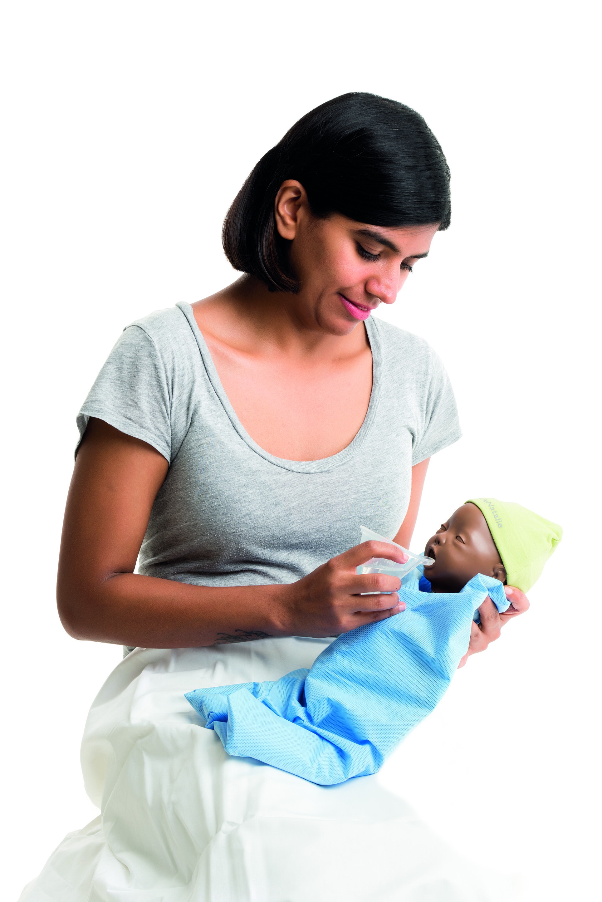 En kvinne mater en babydukke med en silikonkopp.