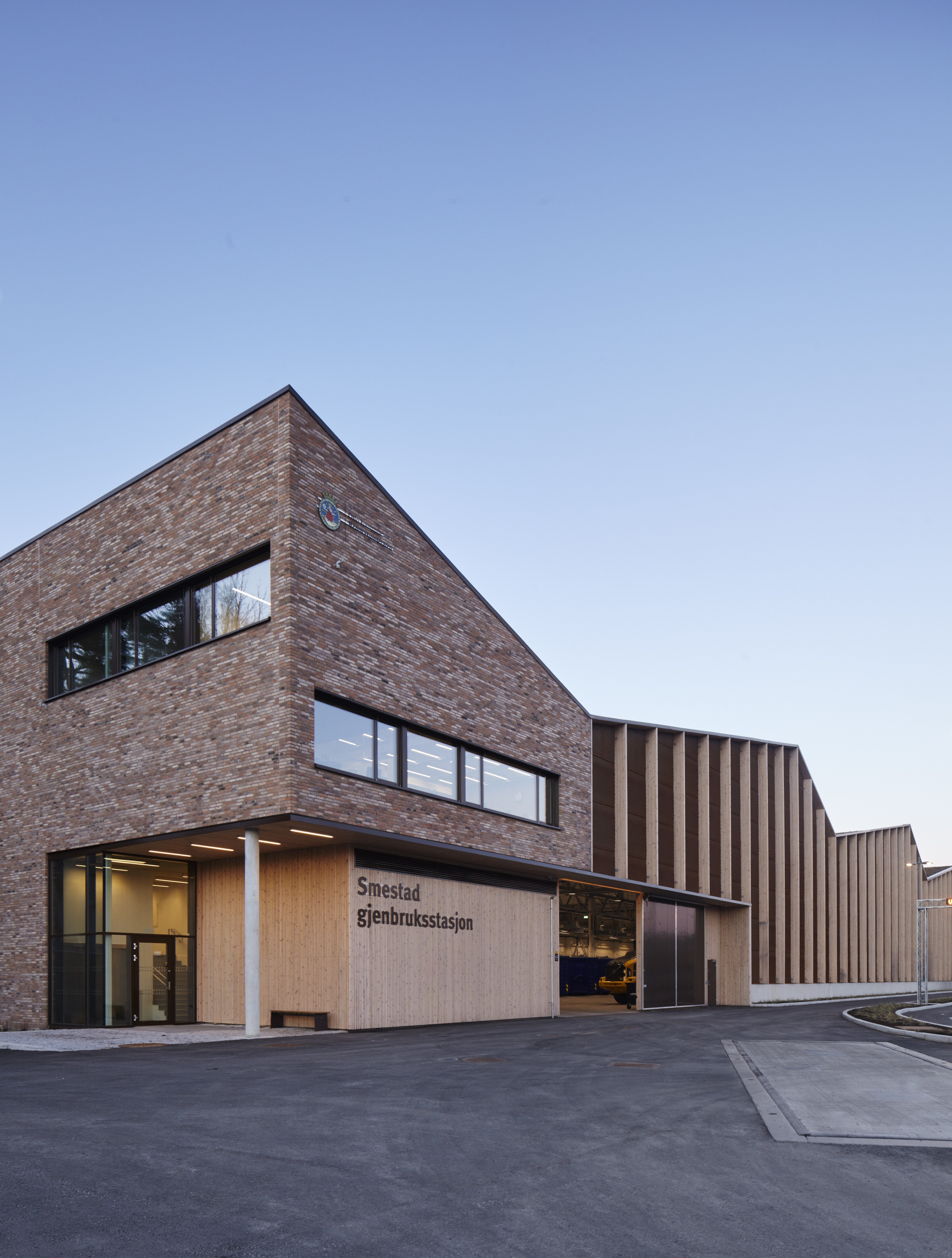 Vinklet bilde av bygget fra administrasjonsinngangen som er i en teglsteinskledd del av bygget.