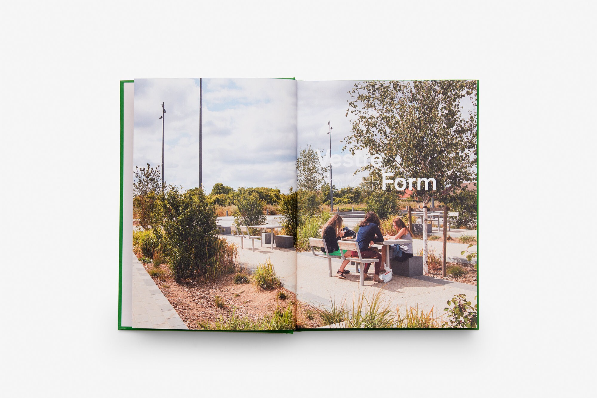 Et oppslag fra en bok: et dobbelsidig foto av et parkområde innredet med sittemøbler. Tittel leser "form".