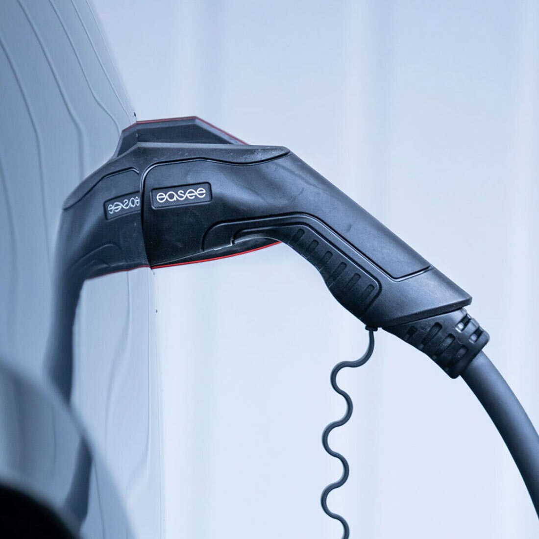 Nærbilde av ladekabel tilkoblet en bil.