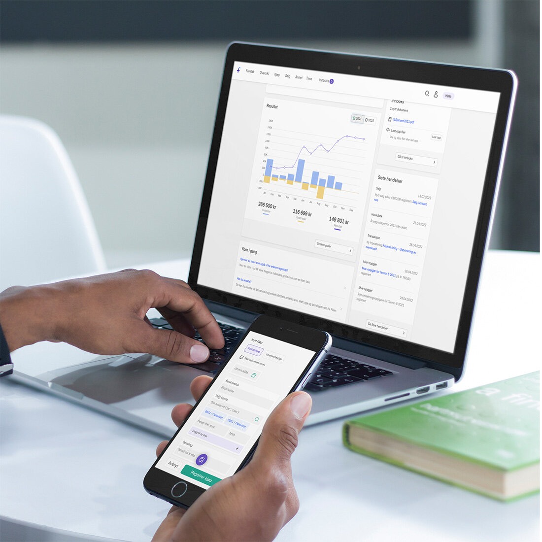 Dataskjerm og mobilskjerm som viser regnskapsprogrammet Fiken.
