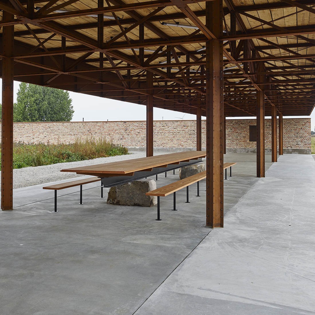 Et langbord med benker under et overbygg