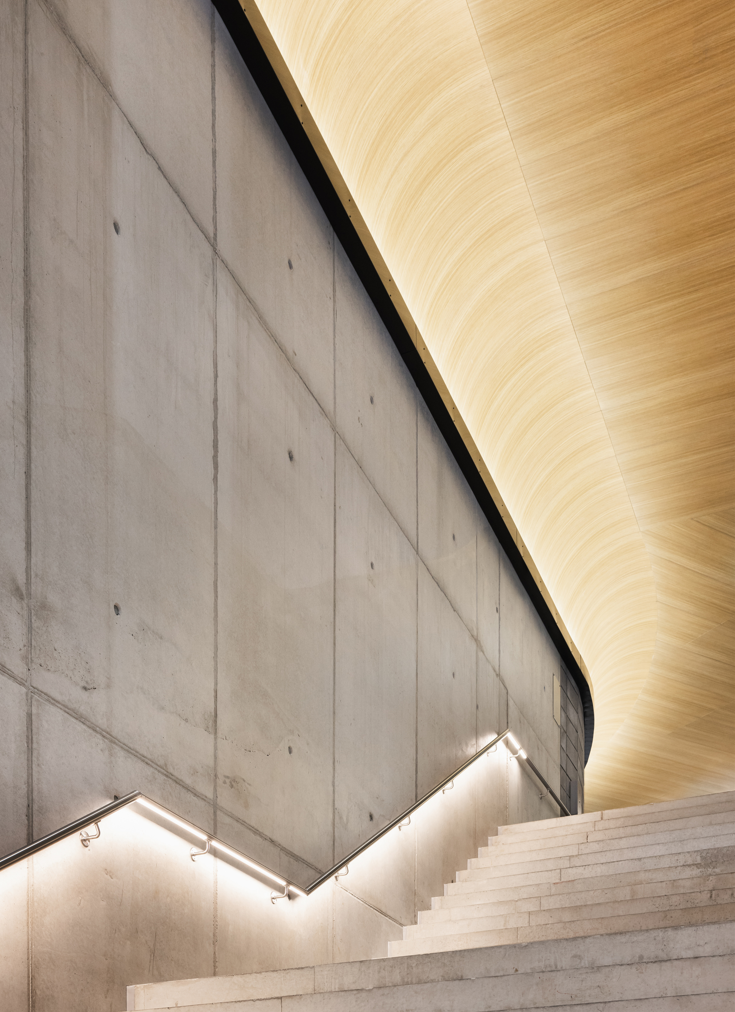 Innvendig trappeoppgang der det er lyst og høyt under taket.