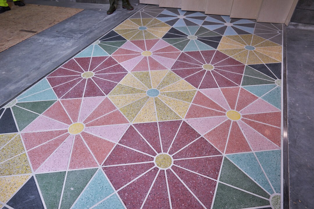 Fliser i rosa og grønt på gulvet.