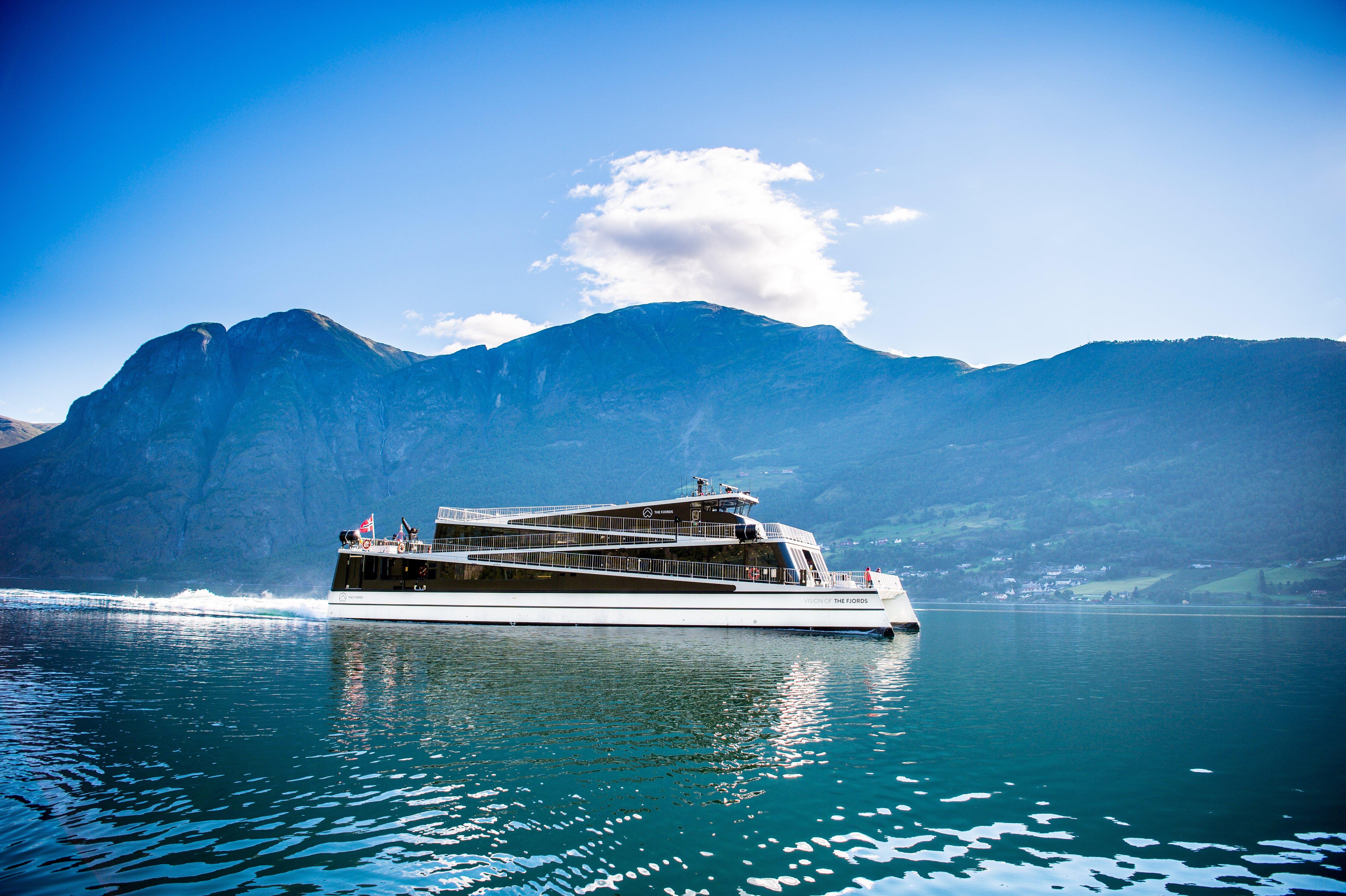 En passasjerbåt i et fjordlandskap