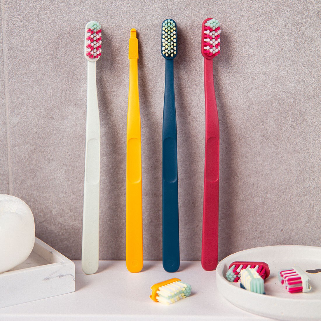 Fire Jordan Change-tannbørster står langs veggen, med løse børstehoder på benken foran.