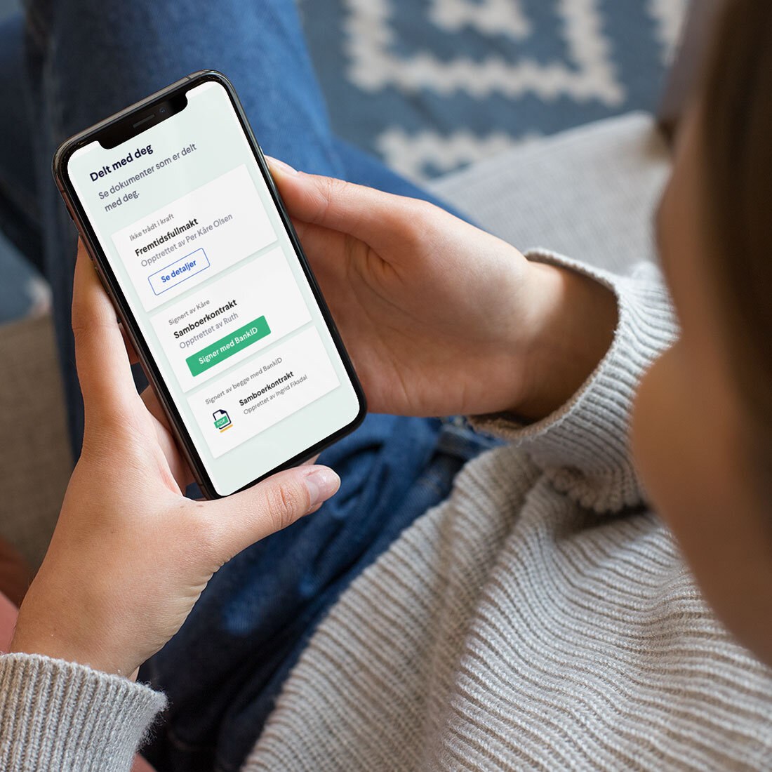 En person holder en mobiltelefon – vi ser kun skjermen på telefonen hvor personen ser en oversikt over dokumenter som andre har delt med vedkommende, blant annet fremtidsfullmakt.