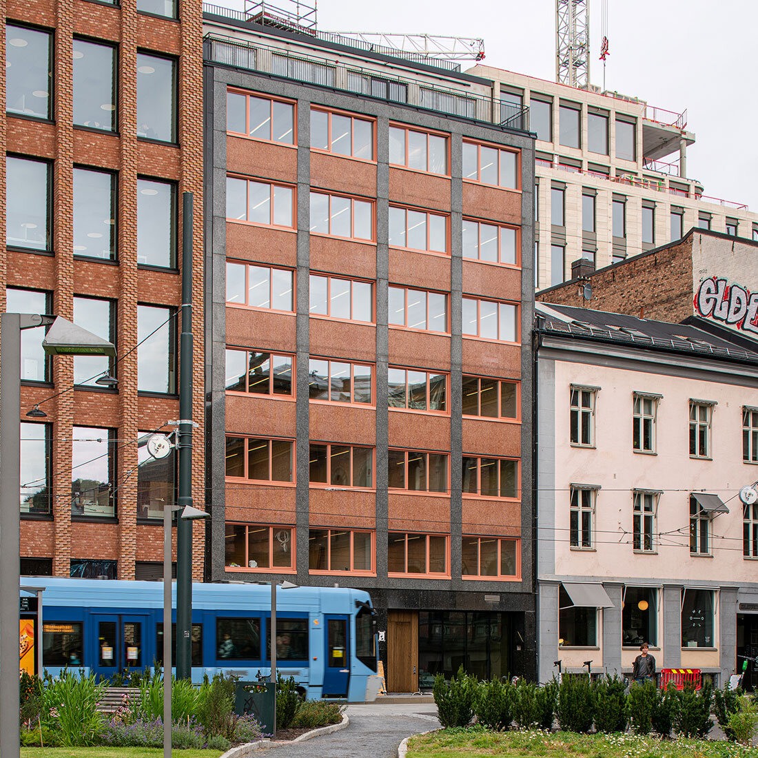 En fasaderekke i et urbant bymiljø sett noe på avstand fra en fotgjengers perspektiv.