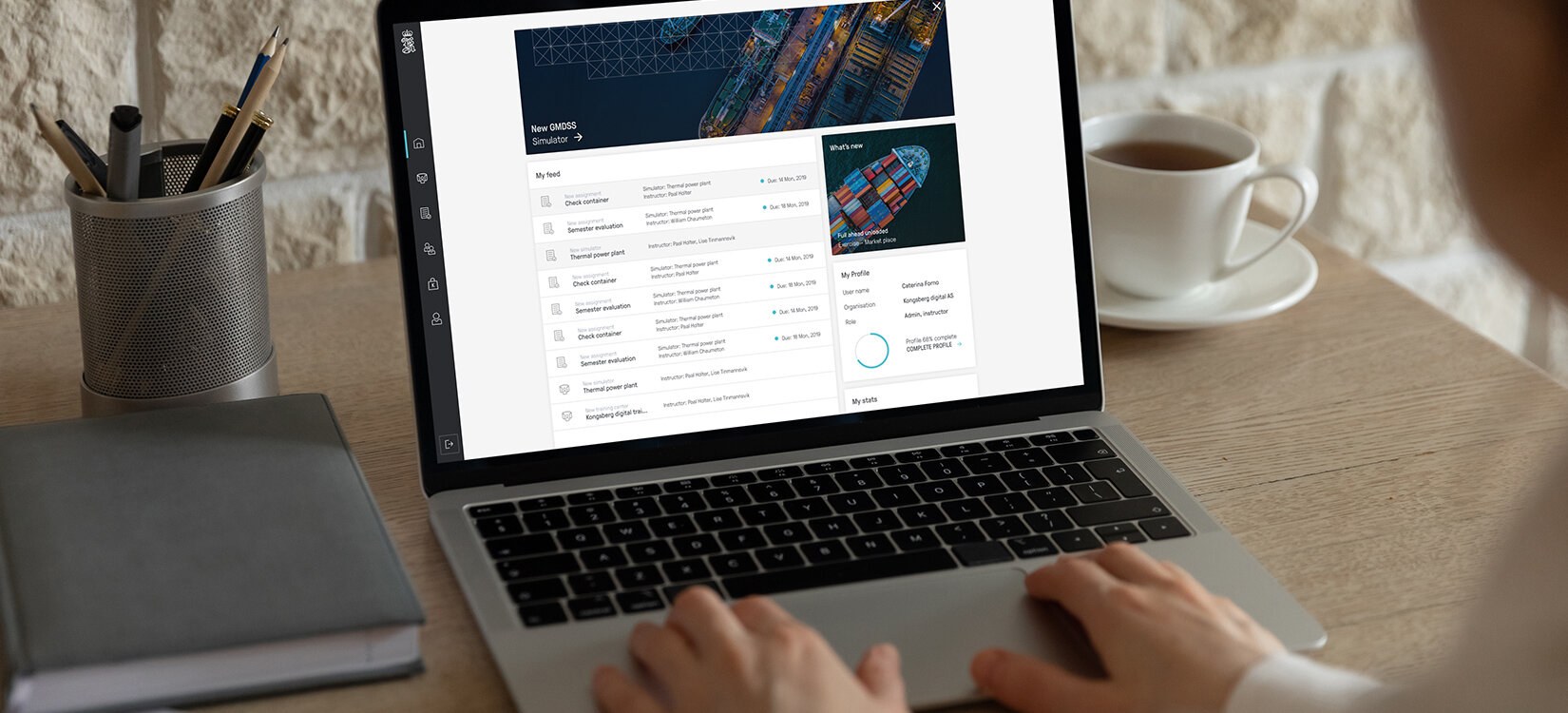 To hender på en laptop. Skjermen viser bilder av lasteskip og ikke lesbar informasjon i en utlisting.